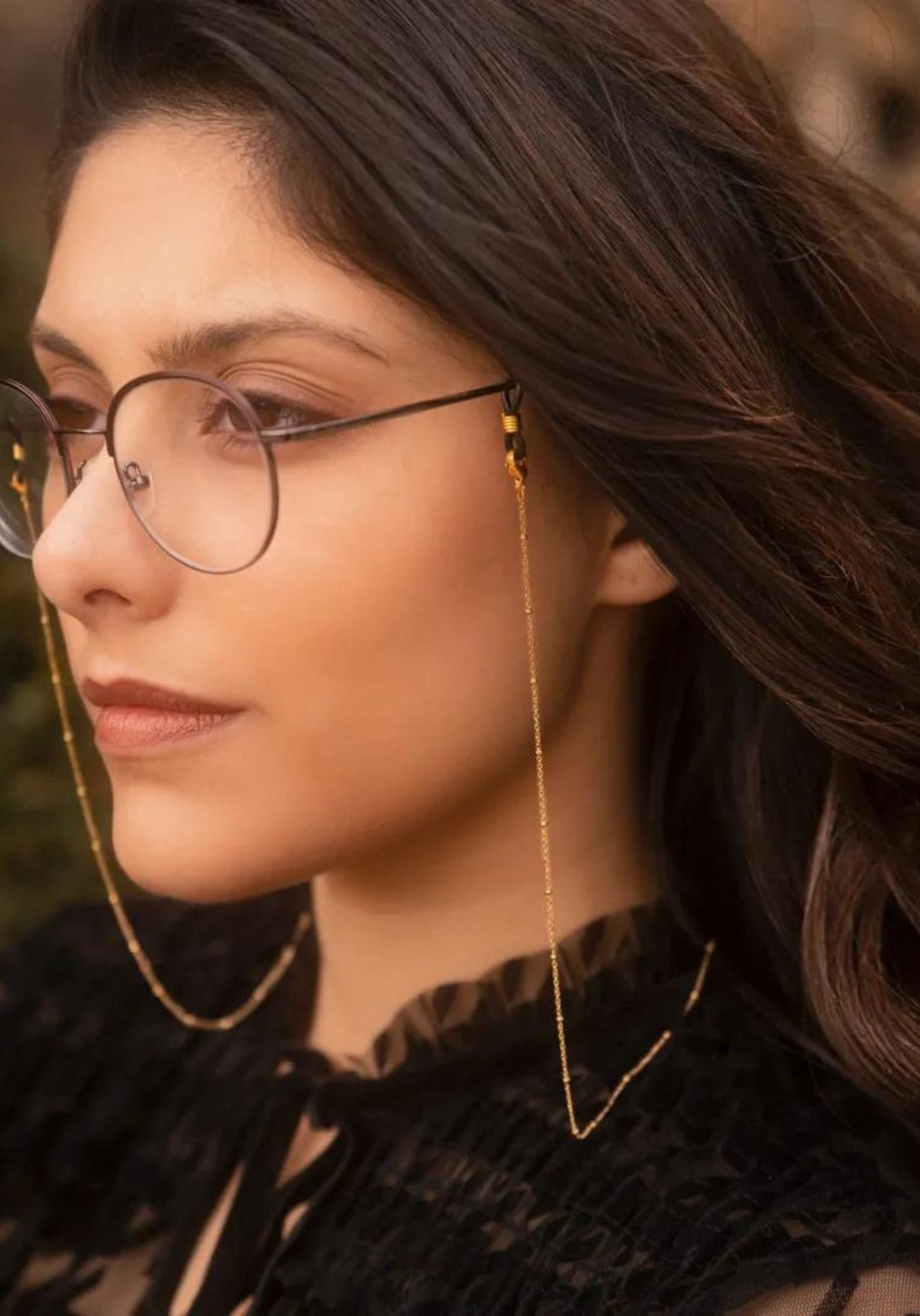La femme porte des lunettes de vue avec la chaîne de lunettes fine dorée Luna de chez Atelier Kat H
