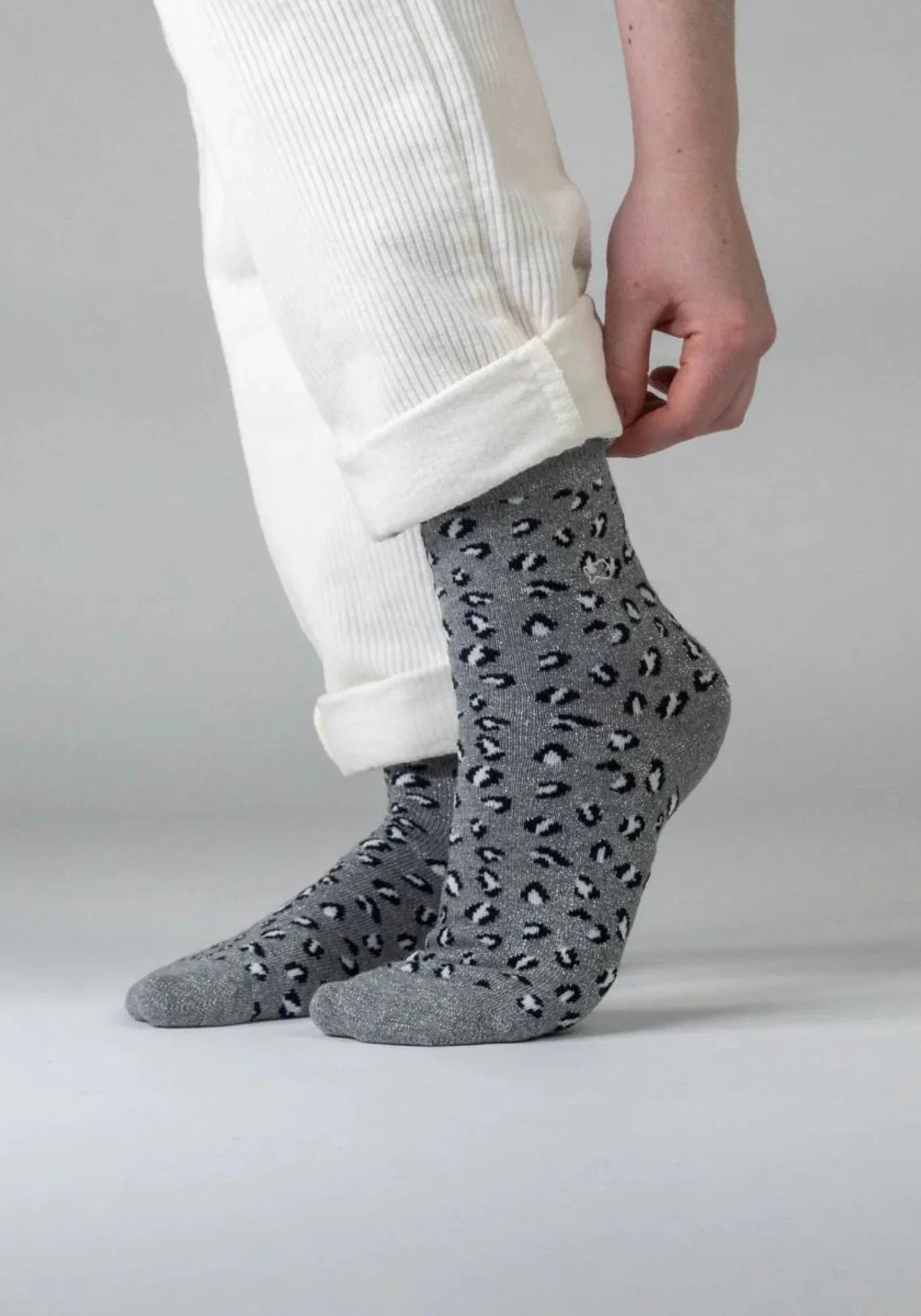 La femme porte les chaussettes à motif léopard gris de chez Billybelt