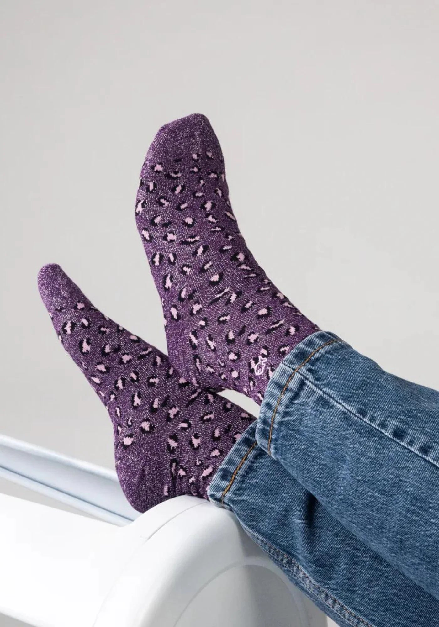 La femme porte les chaussettes à motif léopard prune de chez Billybelt