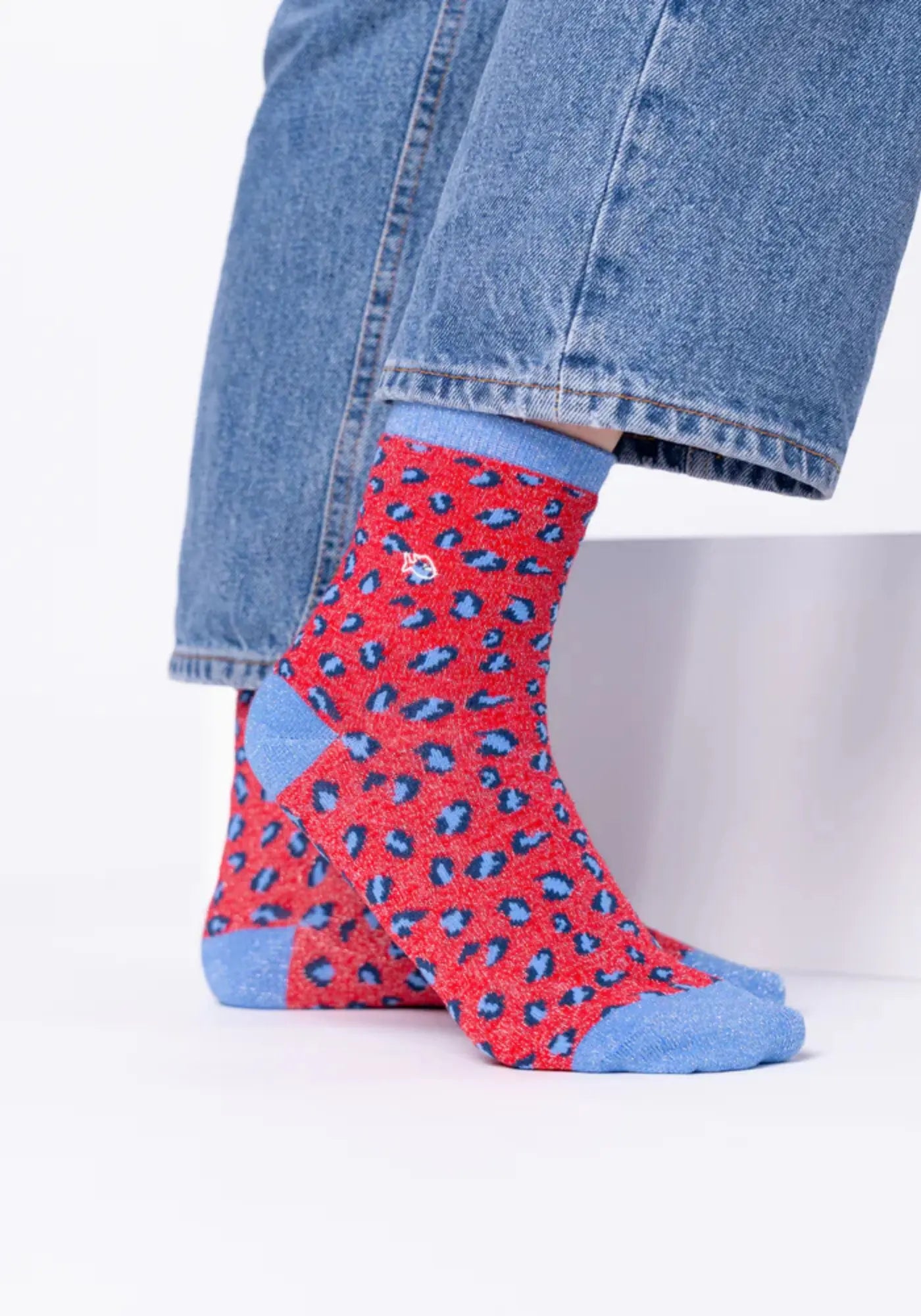 La femme porte les chaussettes à motif léopard rouge et blanc de chez Billybelt