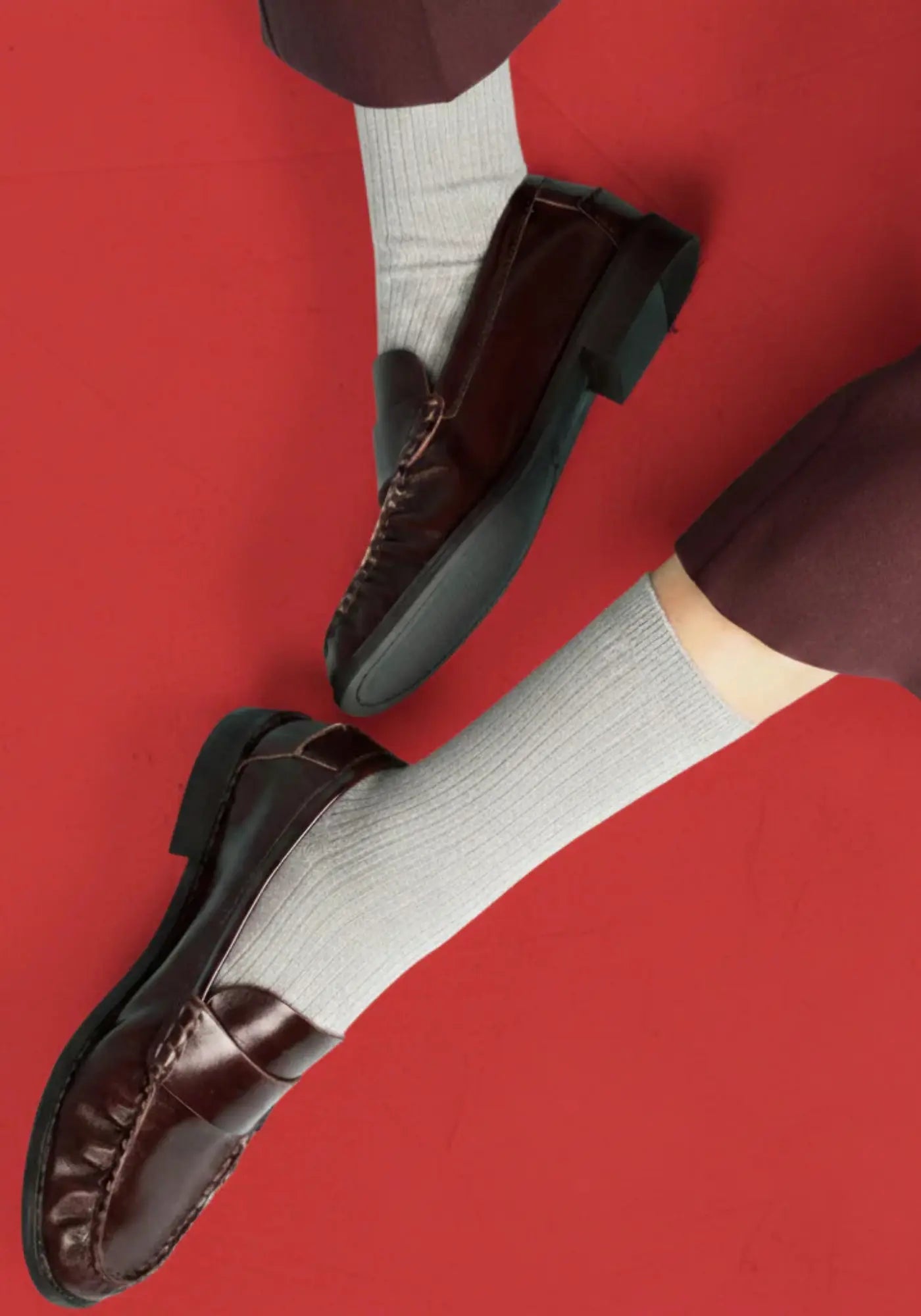 Le mannequin porte les chaussettes en coton biologique light grey de chez Klue 