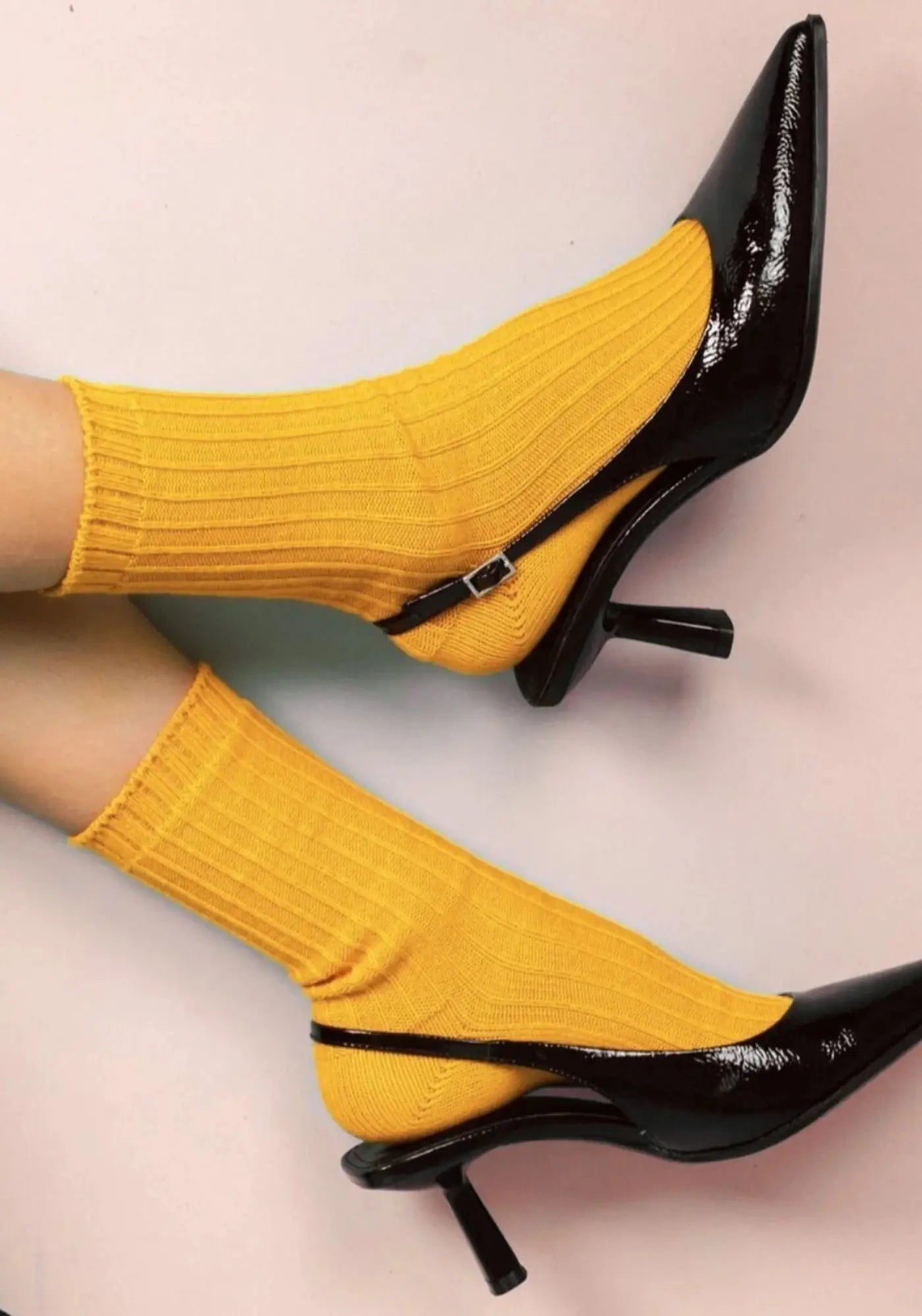Le mannequin porte les chaussettes en coton biologique mustard solid knitted de chez Klue