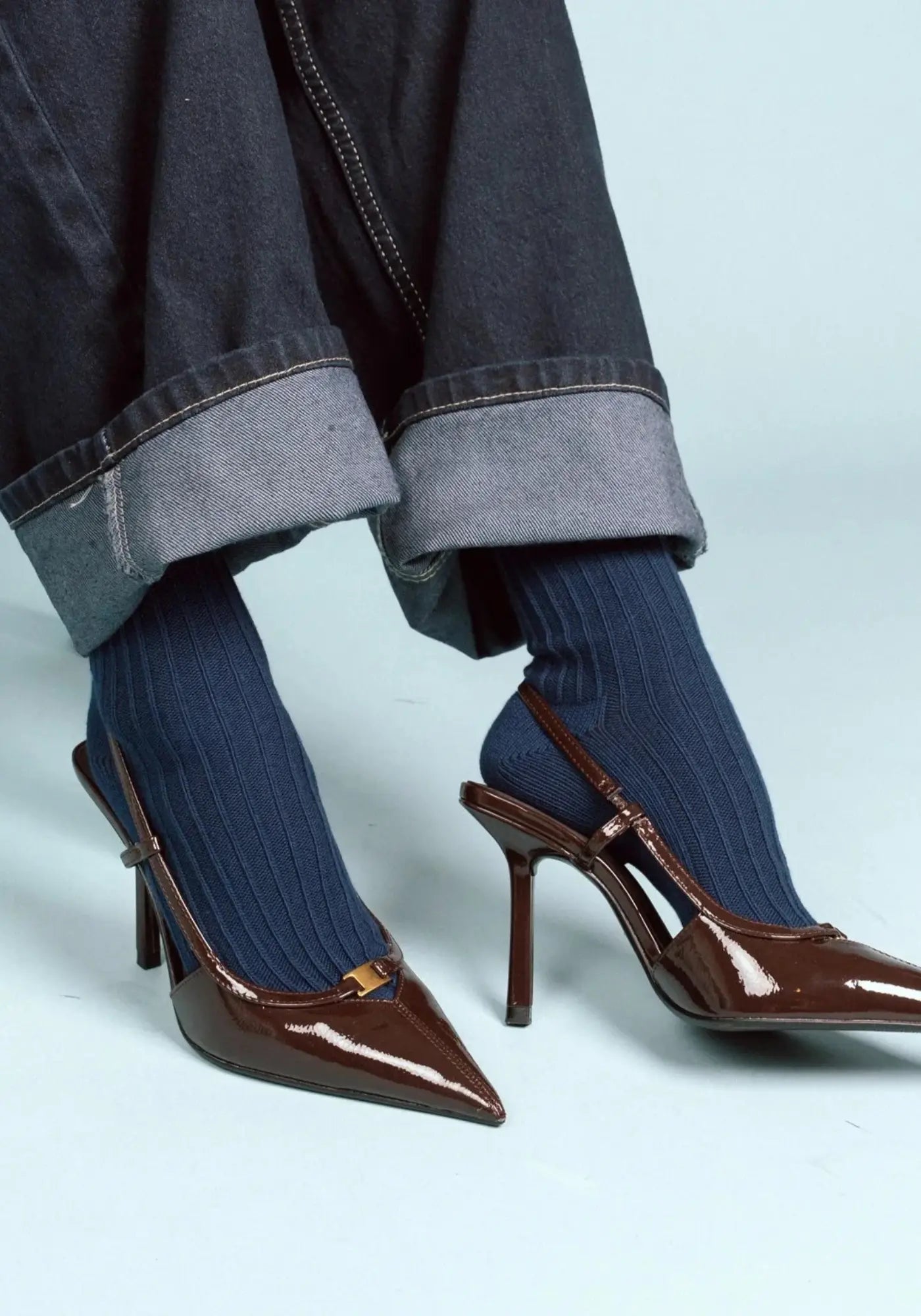 Le mannequin porte les chaussettes en coton biologique navy solid knitted de chez Klue 