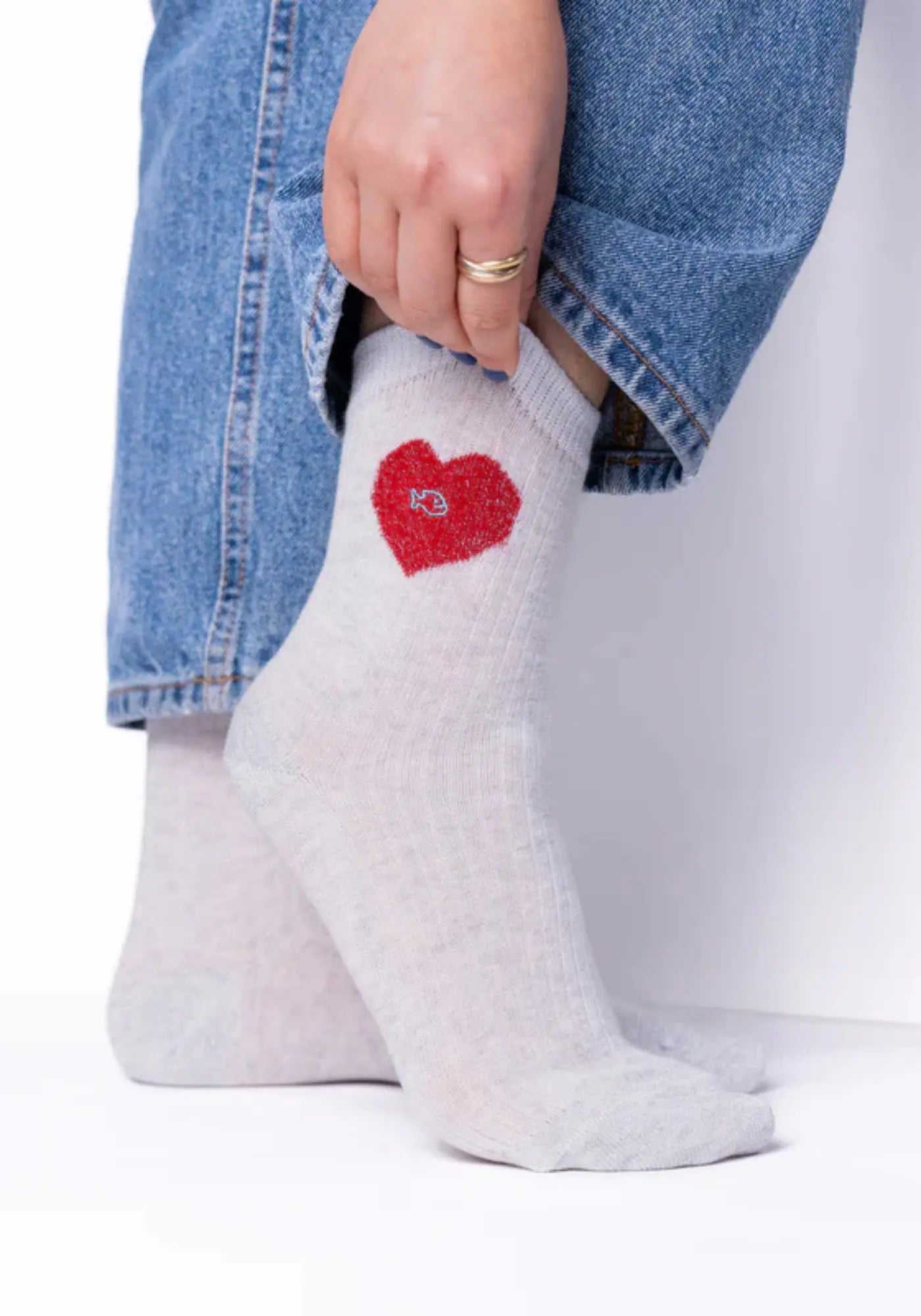 La femme porte les chaussettes en coton peigné coeur blanc et rouge de chez Billybelt 