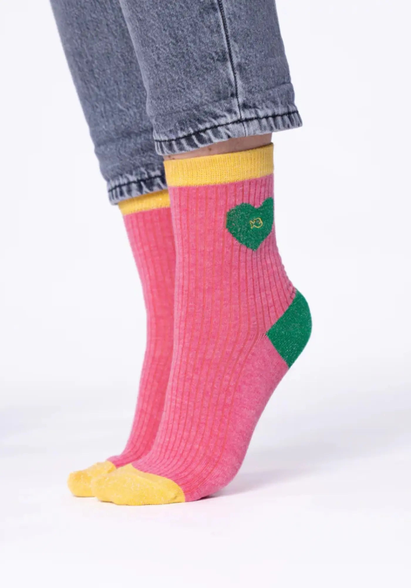 La femme porte les chaussettes en coton peigné coeur rose et vert de chez Billybelt 