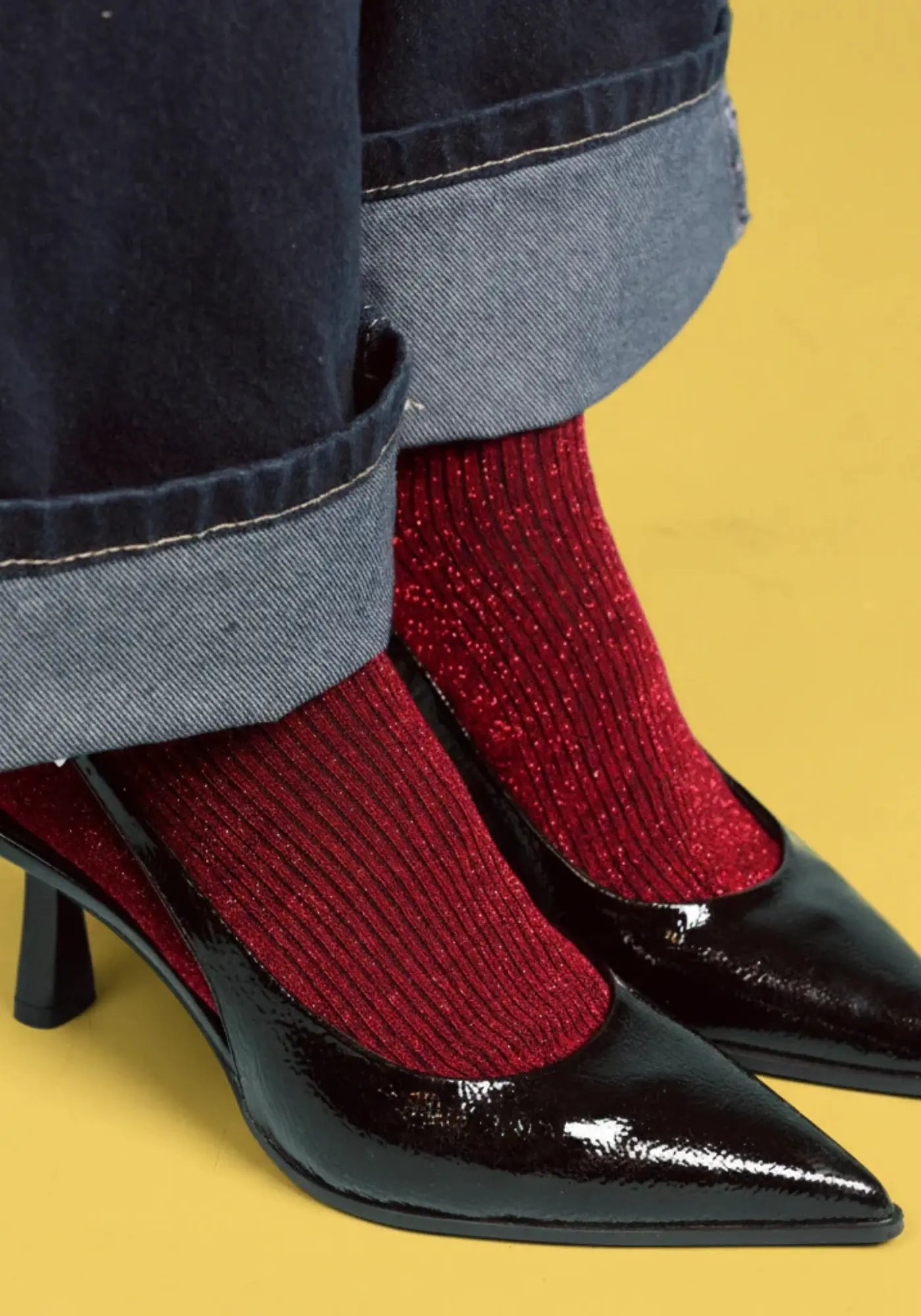 Le mannequin porte les chaussettes lurex cerise de chez Klue