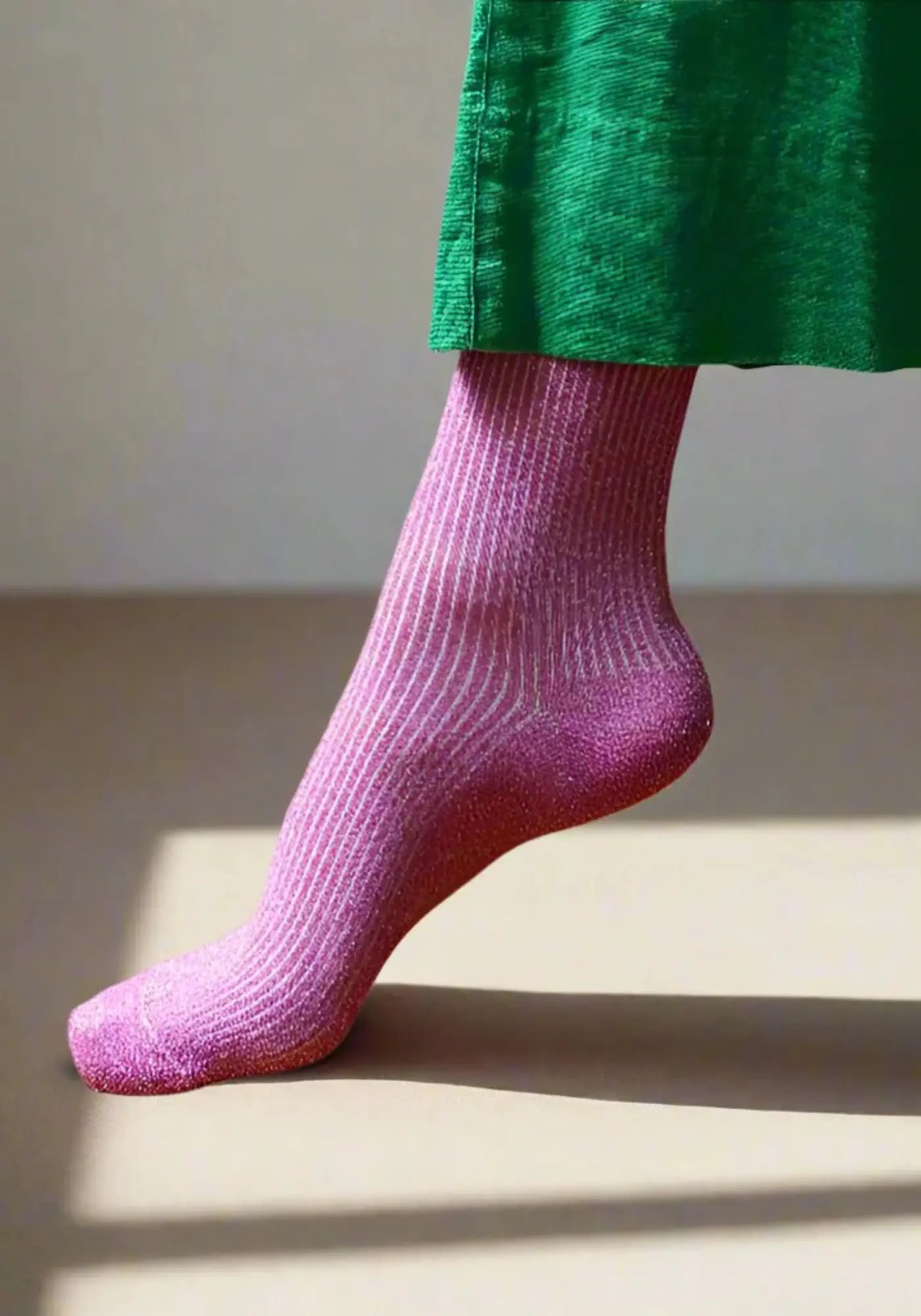 Le mannequin porte les chaussettes lurex fuchsia de chez Klue