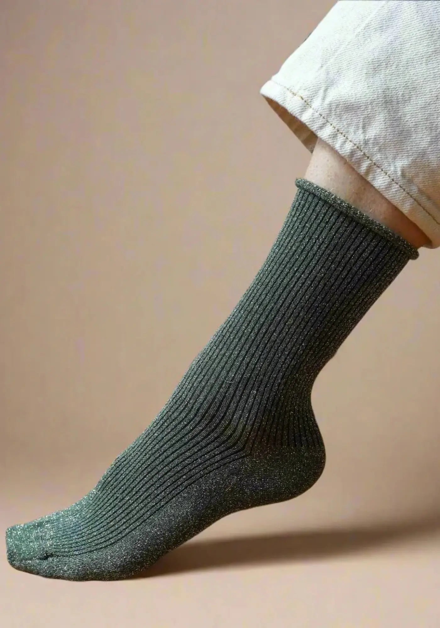 Le mannequin porte les chaussettes lurex kaki de chez Klue