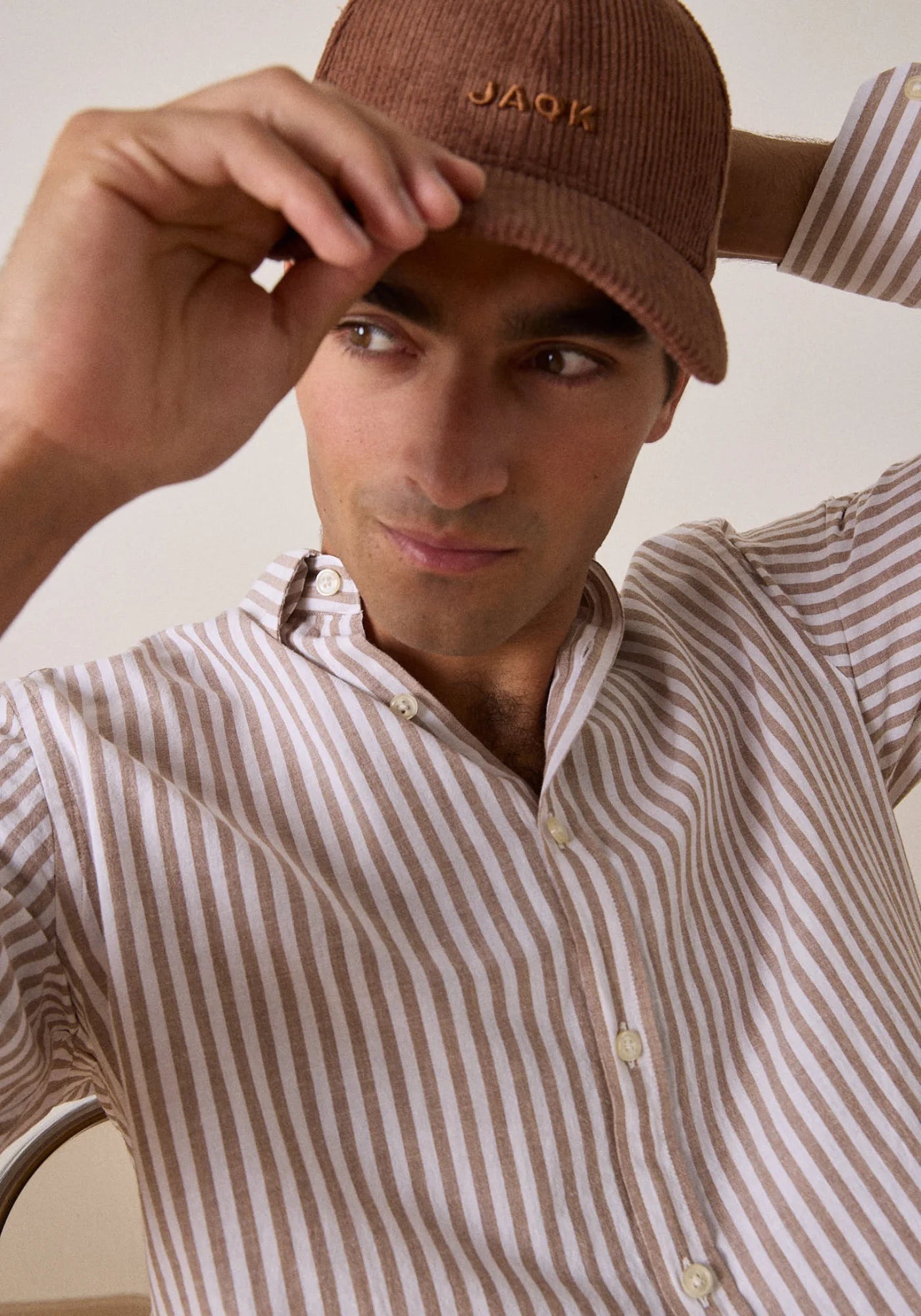 L'homme tient sa casquette et porte la chemise Five Carpenter de chez Jaqk