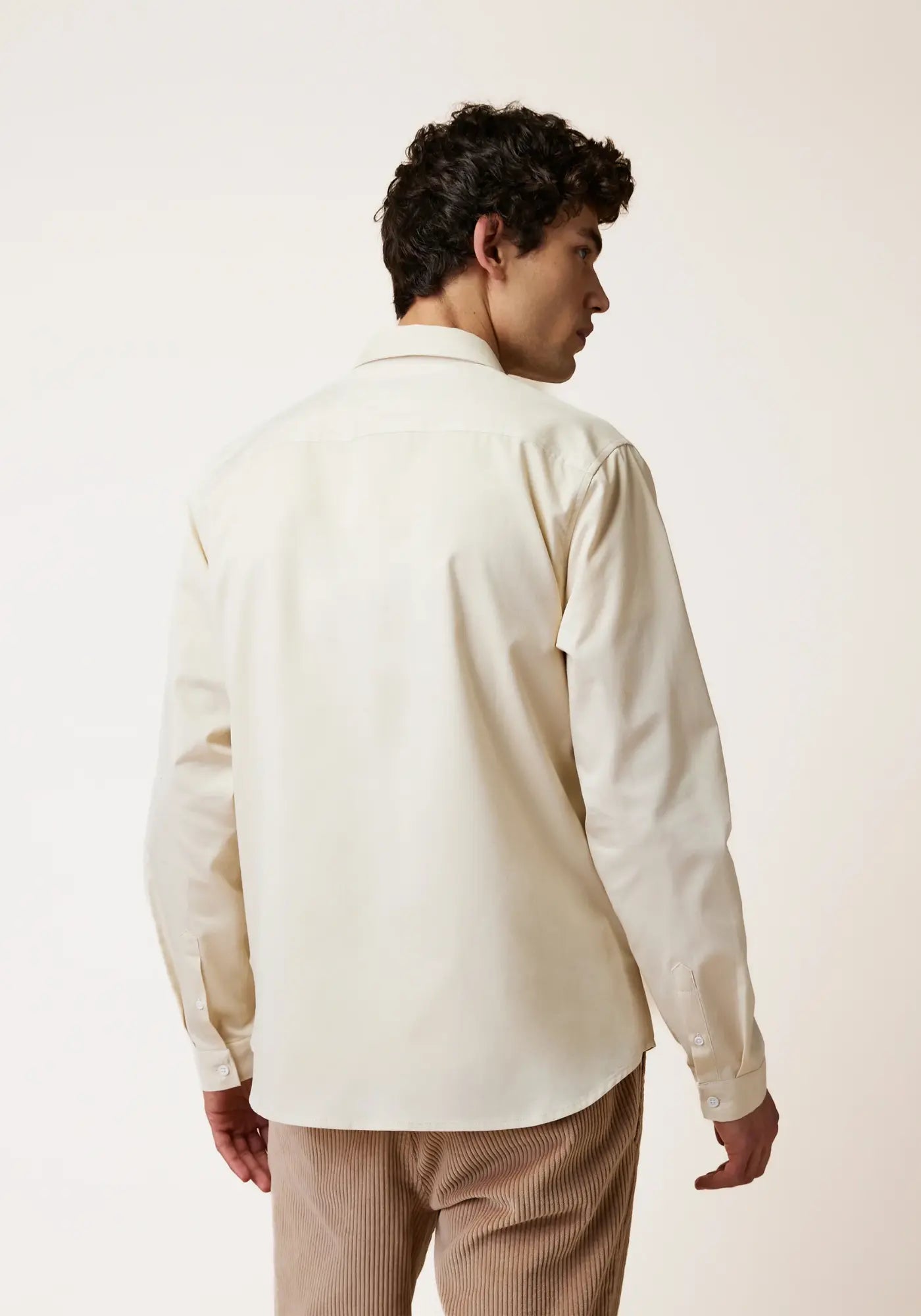 L'homme est de dos et porte la chemise Iraty écru de chez Faguo