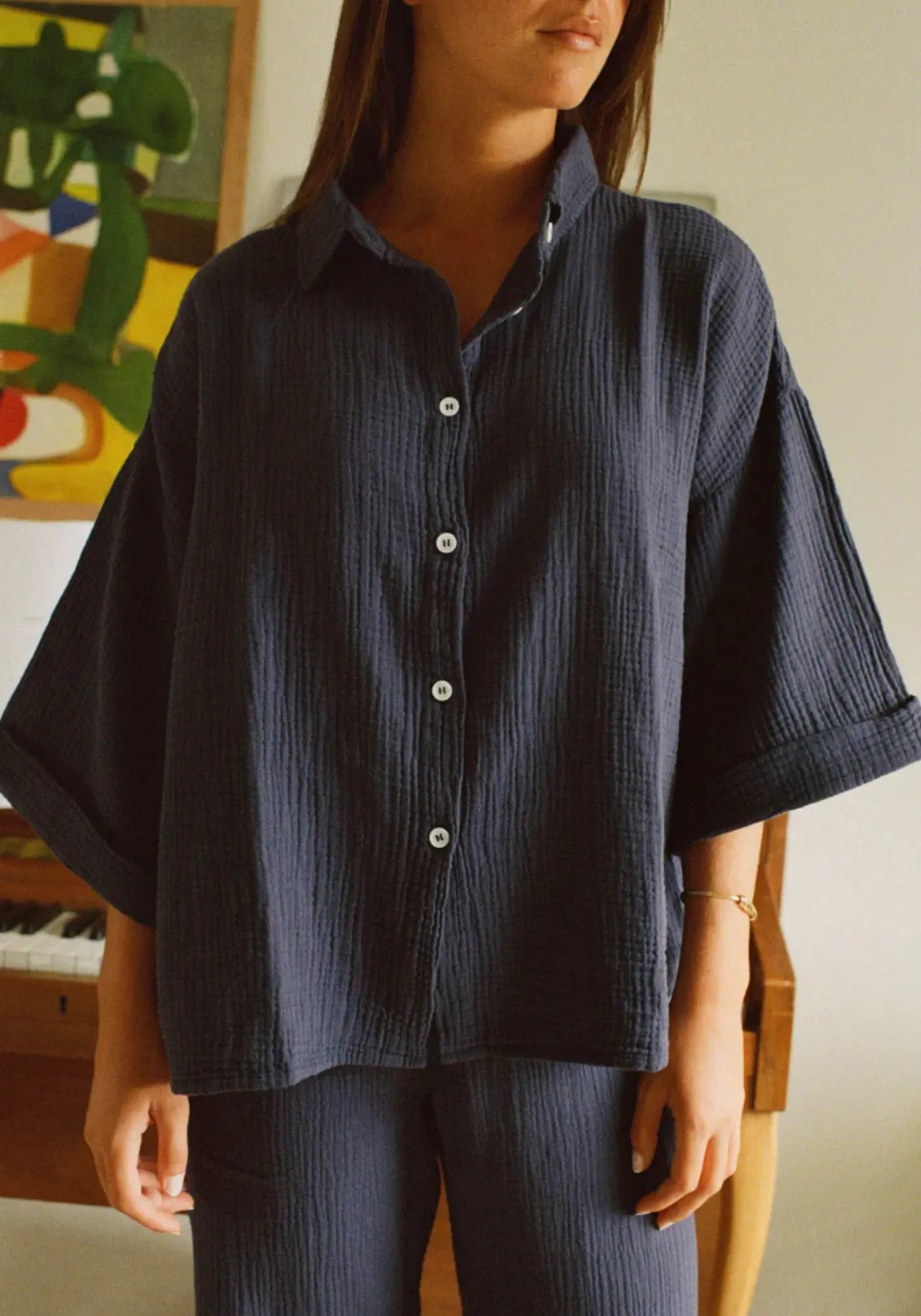 La femme porte la chemise mimosa bleu de chez Nénés Paris 