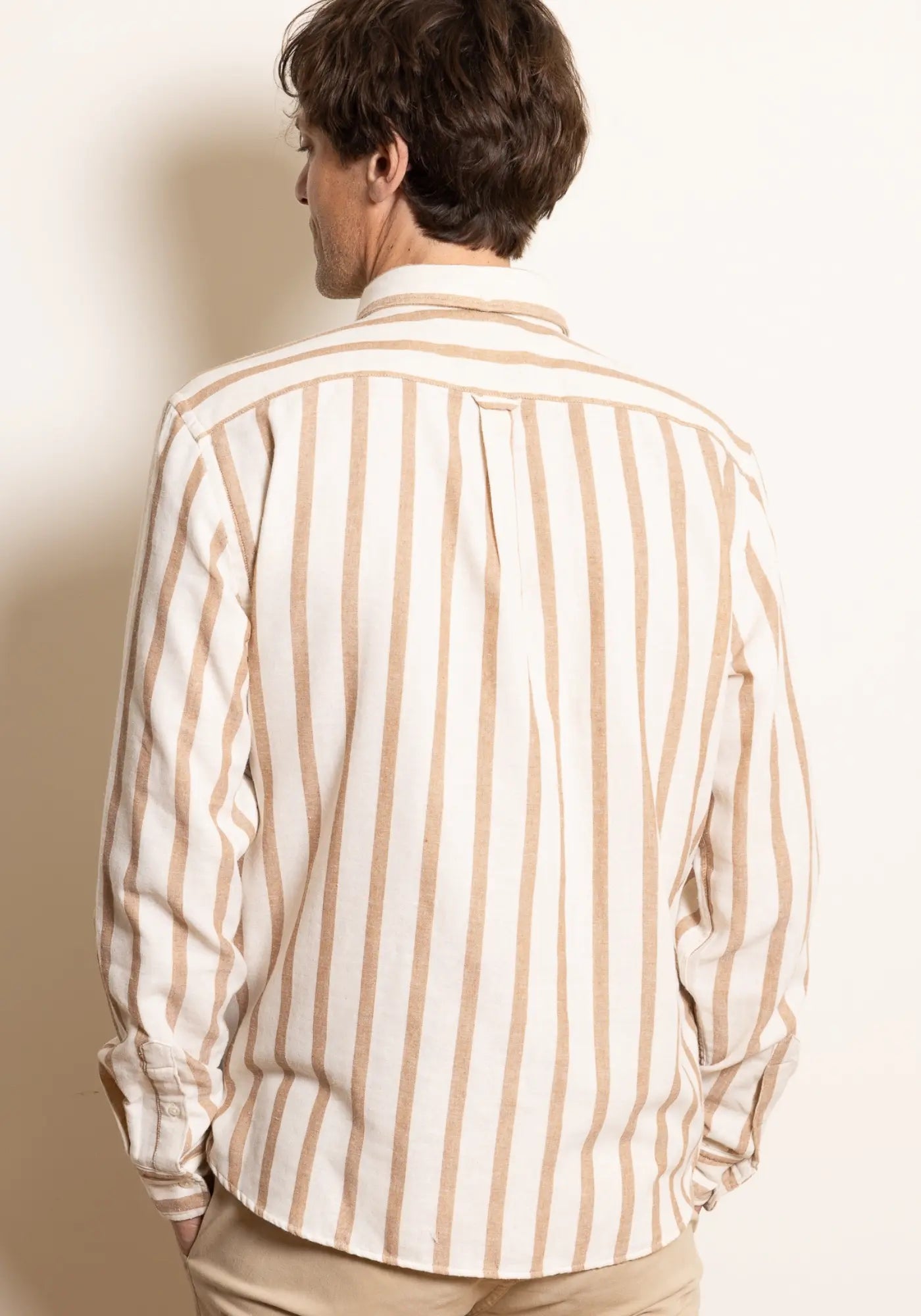 L'homme est de dos et porte la chemise rayée Java ocre de chez Jaqk 