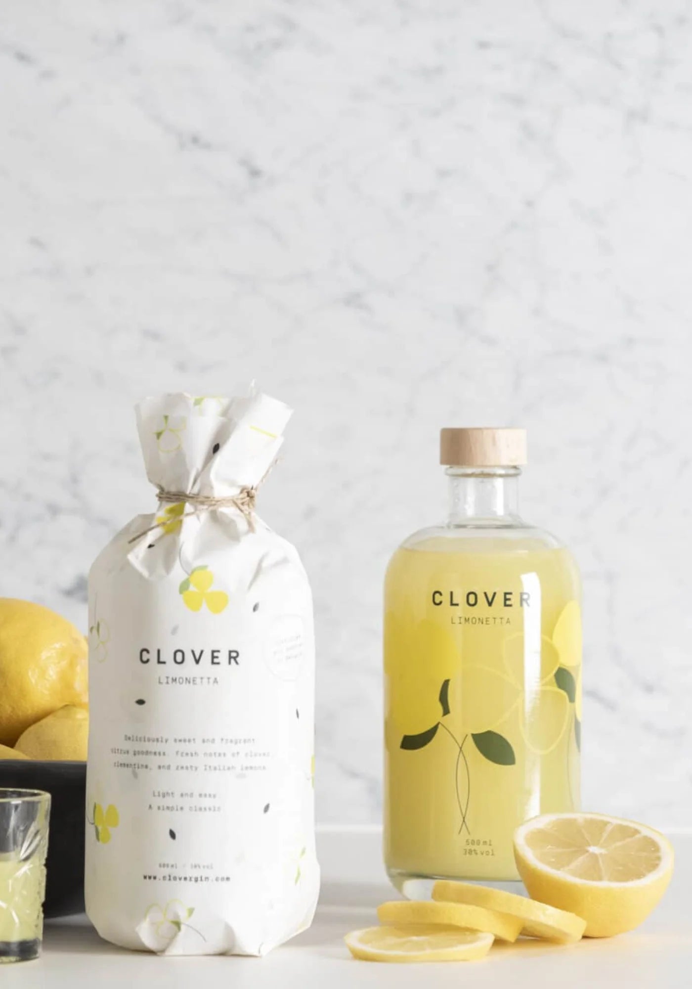 Le Clover Limonetta de chez Clover Gin accompagnée d'une deuxième bouteille emballée et de citrons