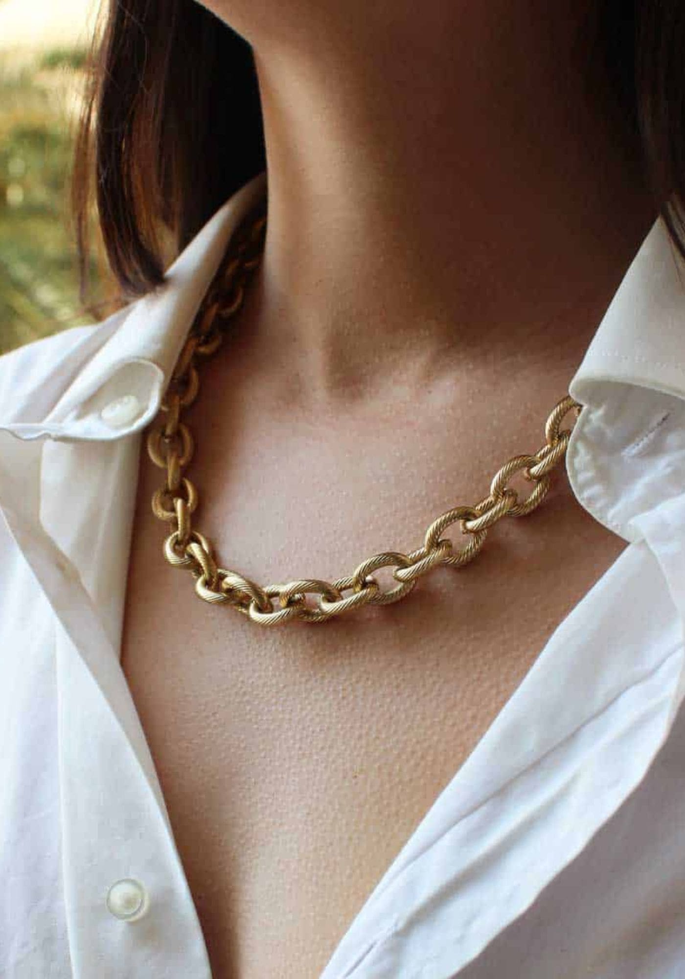 La femme porte le collier rita en grosse chaine doré