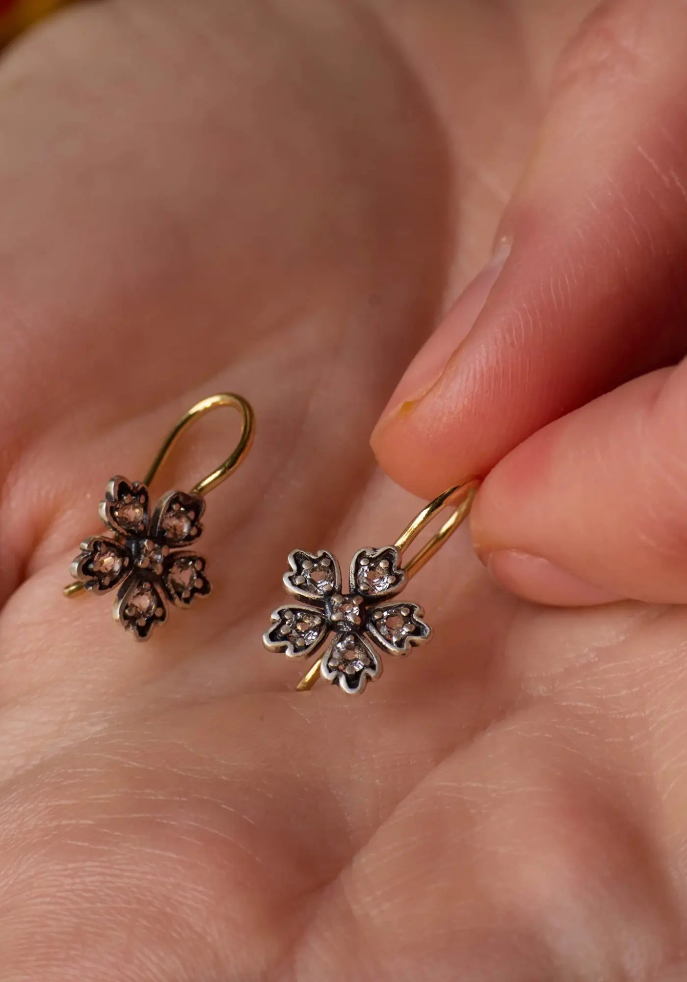 La femme tient les boucles d'oreilles Daisy de chez Dorothée Sausset 