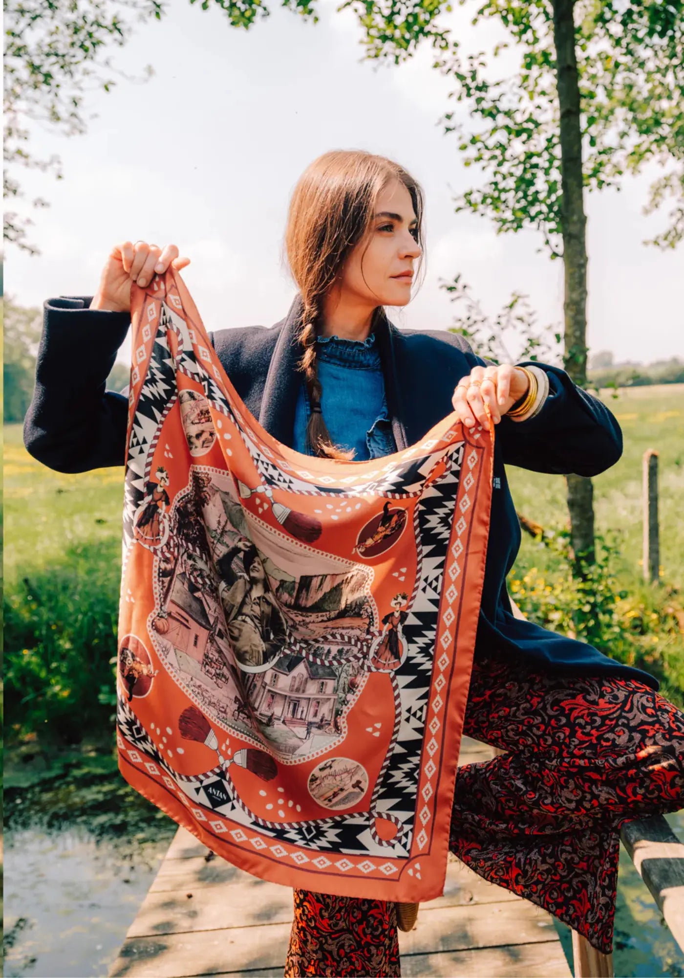 La femme porte le foulard dusty west silk 70 brick de chez Antan Créations