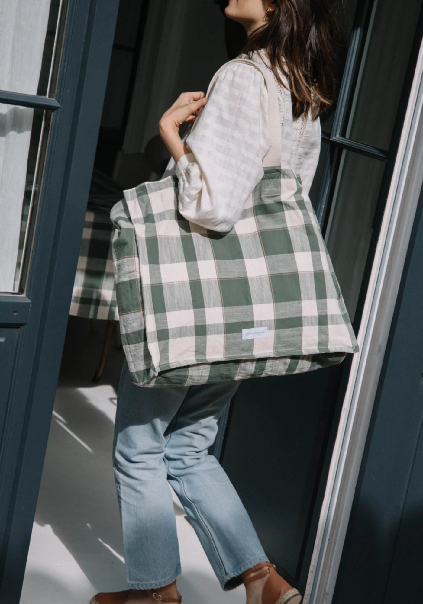 La femme porte le grand sac cabas jacquard carreaux vert de chez Les Pensionnaires