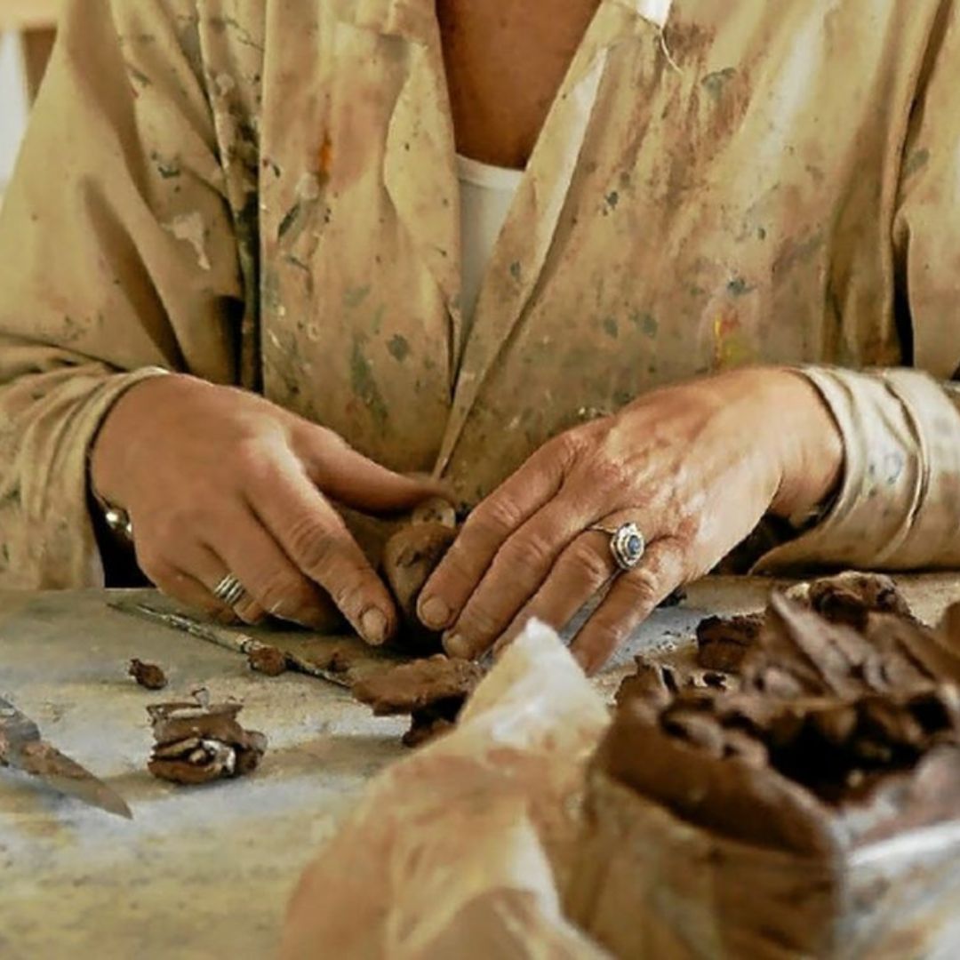Zoom sur les mains de l'artiste Guénolée Courcoux qui travaille une sculpture 