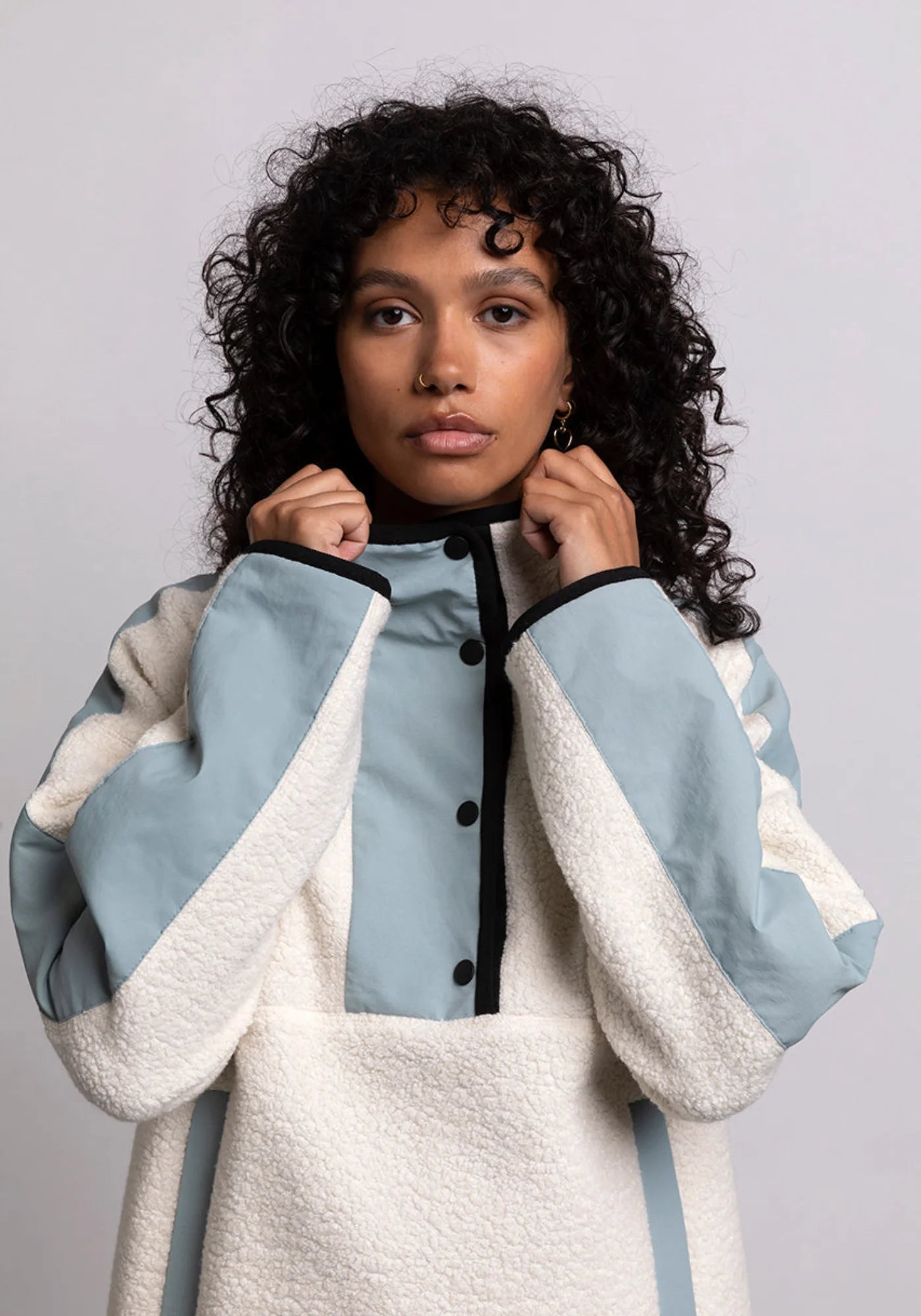 Zoom sur la femme qui porte le hoodie Sherpa unisexe Cocoon écrue et bleue de chez Mout Mout