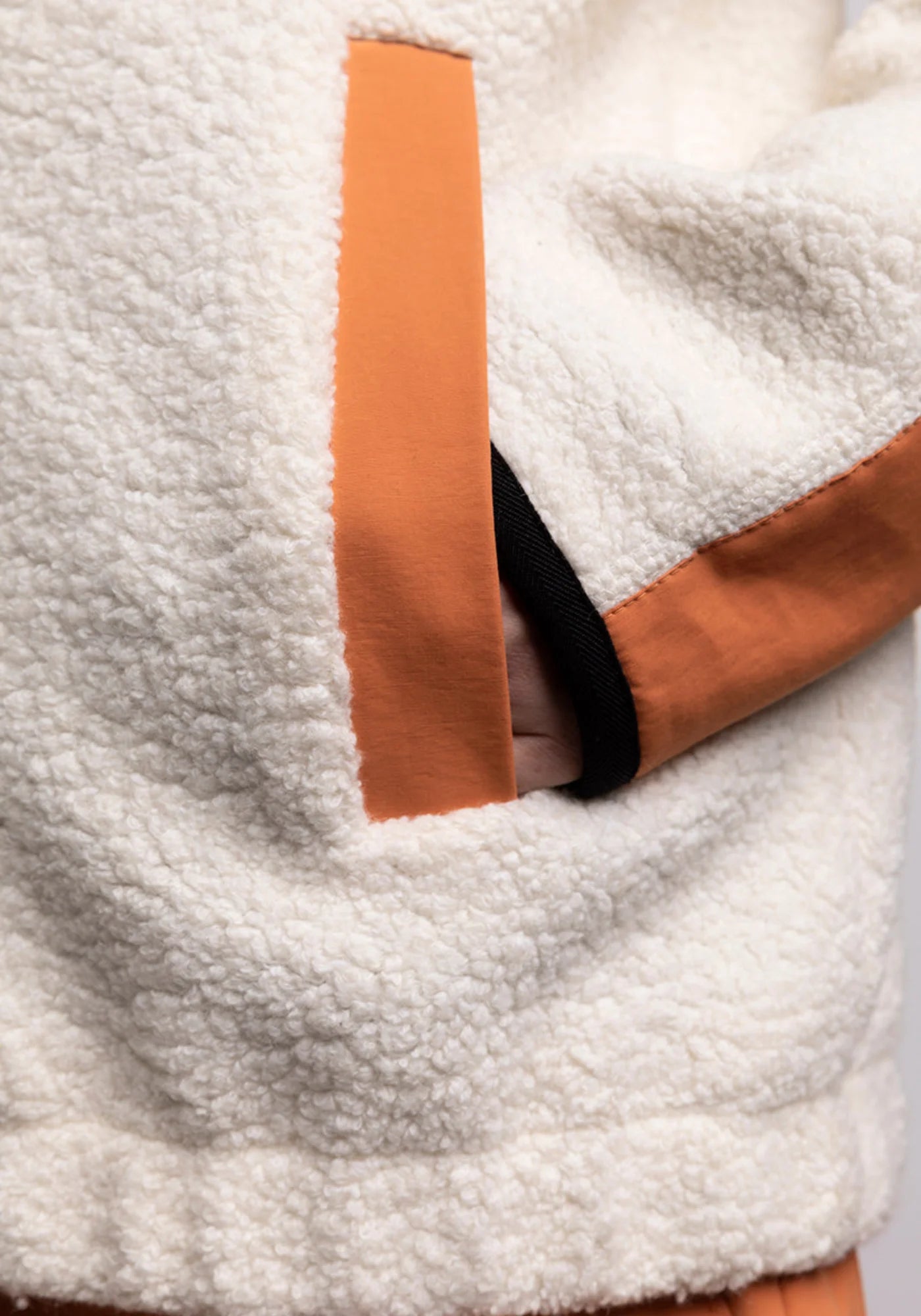 Zoom sur la poche du hoodie Sherpa unisexe Cocoon écrue et orange de chez Mout Mout