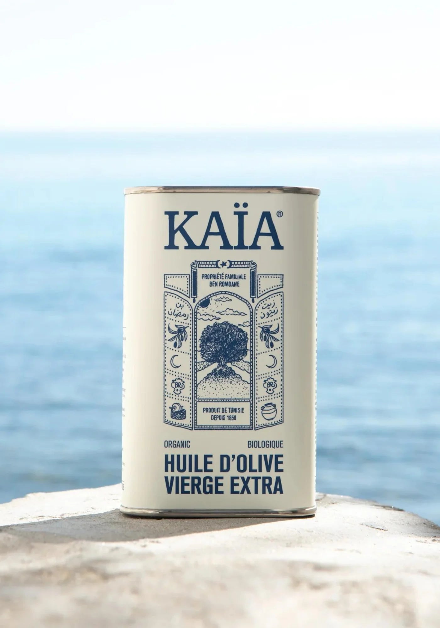 L'huile d'olive bio en 50 cl de chez Kaïa posée sur une pierre face à la mer