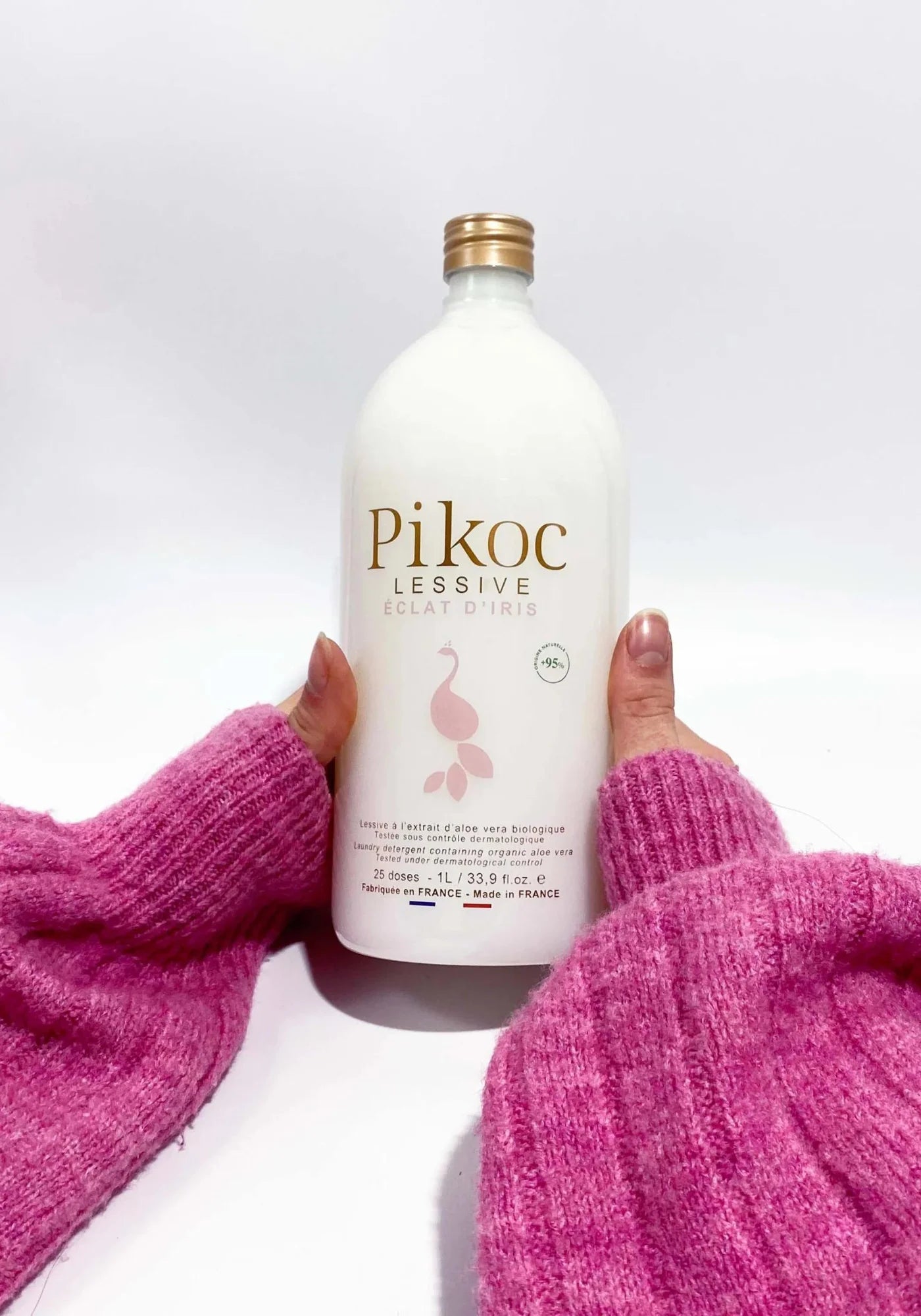 La femme tient entre ses mains la lessive éclat d'iris de chez Pikoc