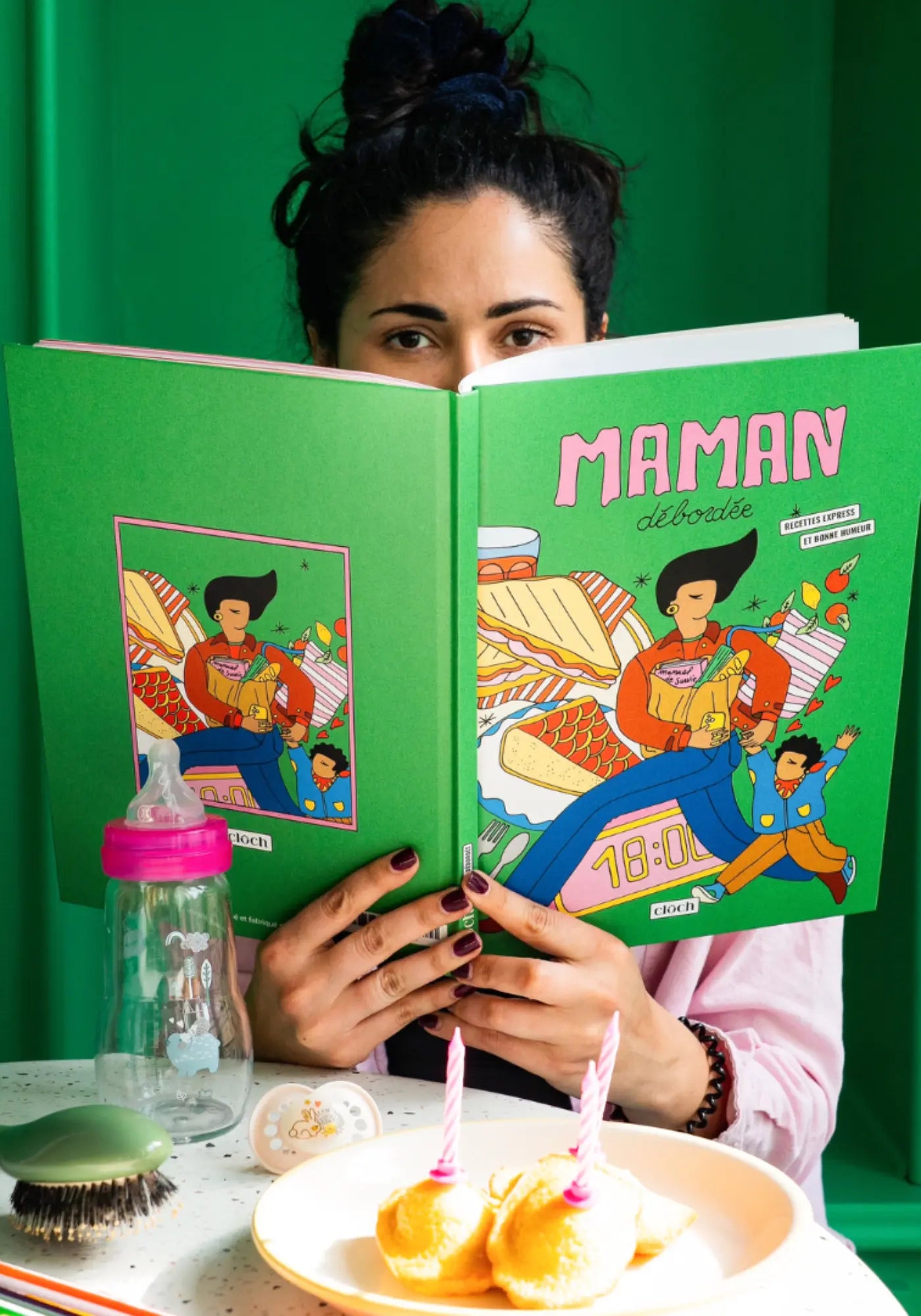La femme tient le livre de recettes maman débordée de chez Cloch