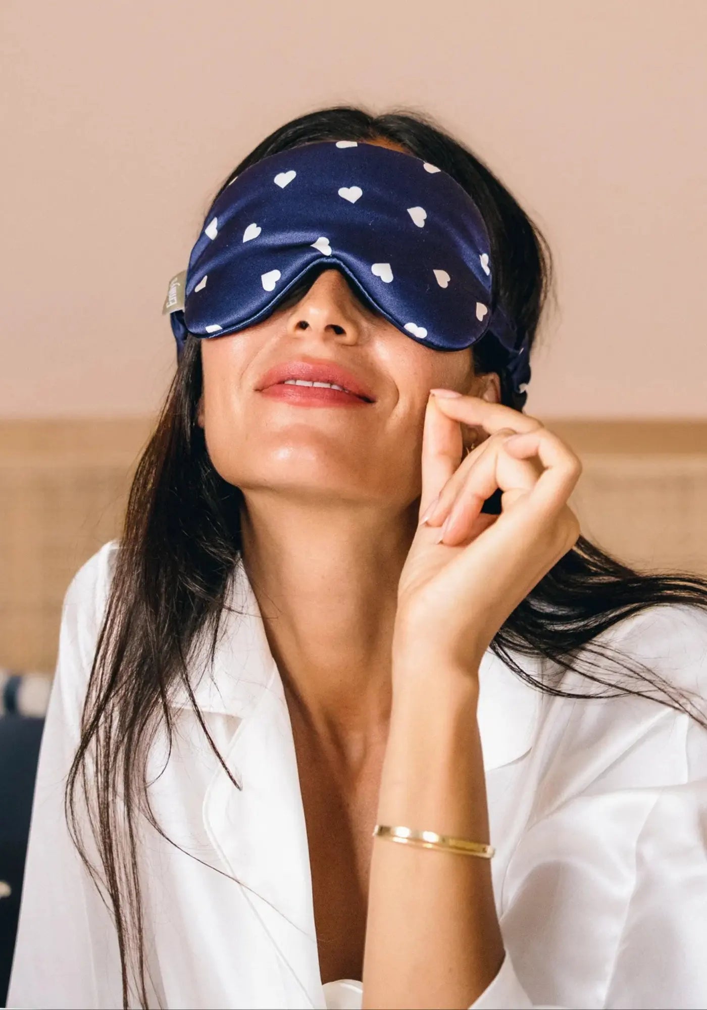 La feme porte le masque de nuit en soie bleu coeur crème de chez Emily's Pillow