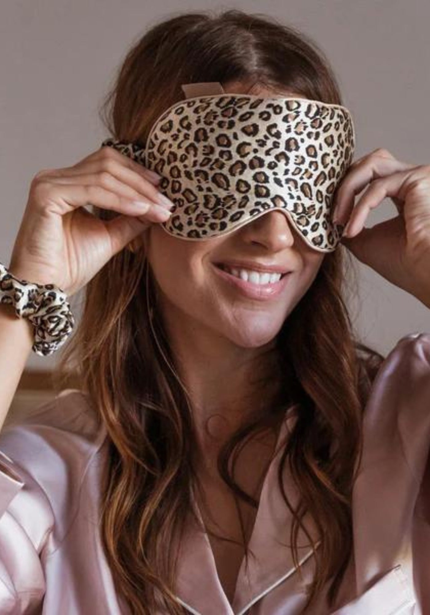 La femme porte le masque de nuit en soie léopard de chez Emily's Pillow