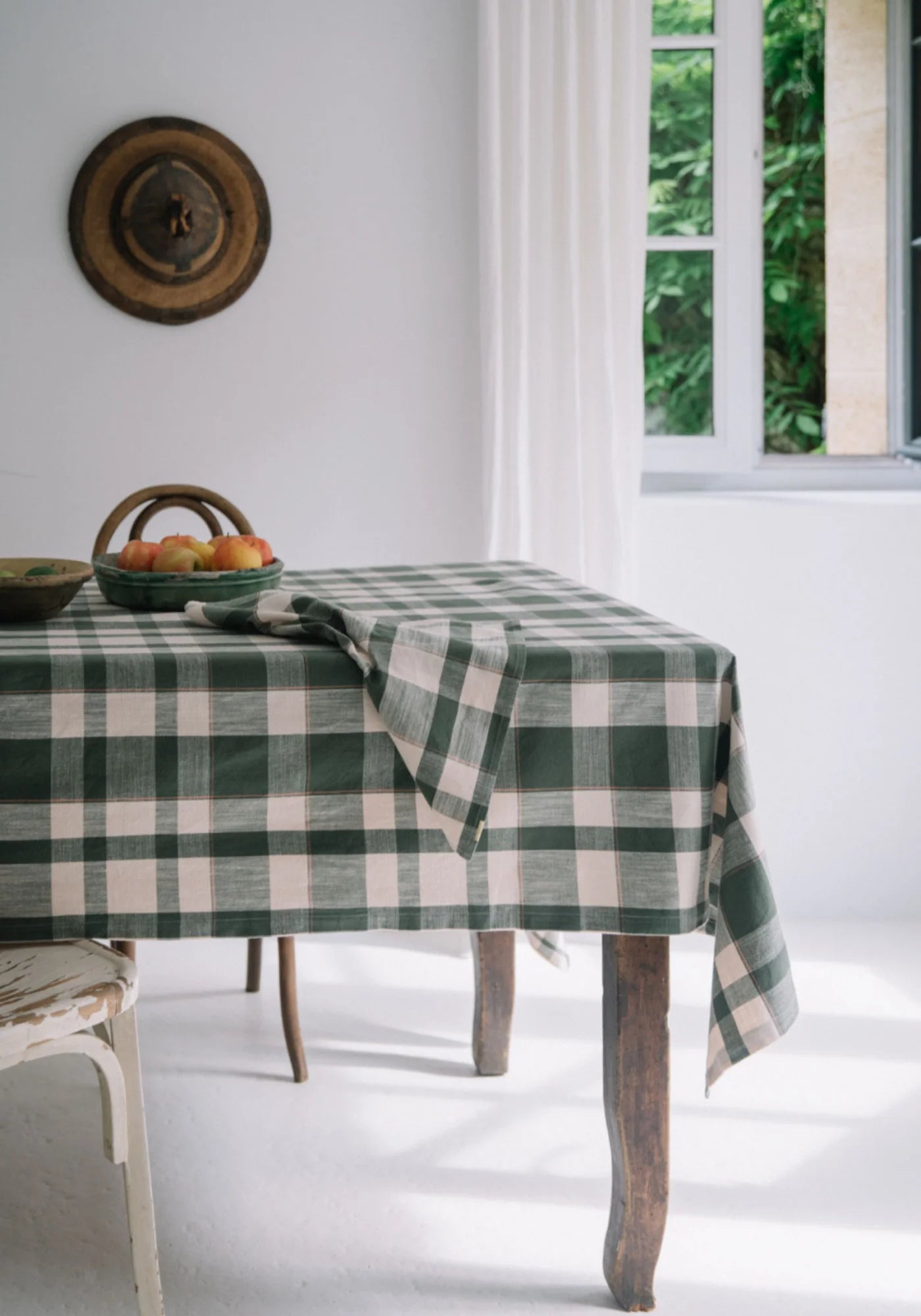 La nappe en jacquard de coton à carreaux vert de chez Les Pensionnaires accompagnée de deux corbeilles de fruits