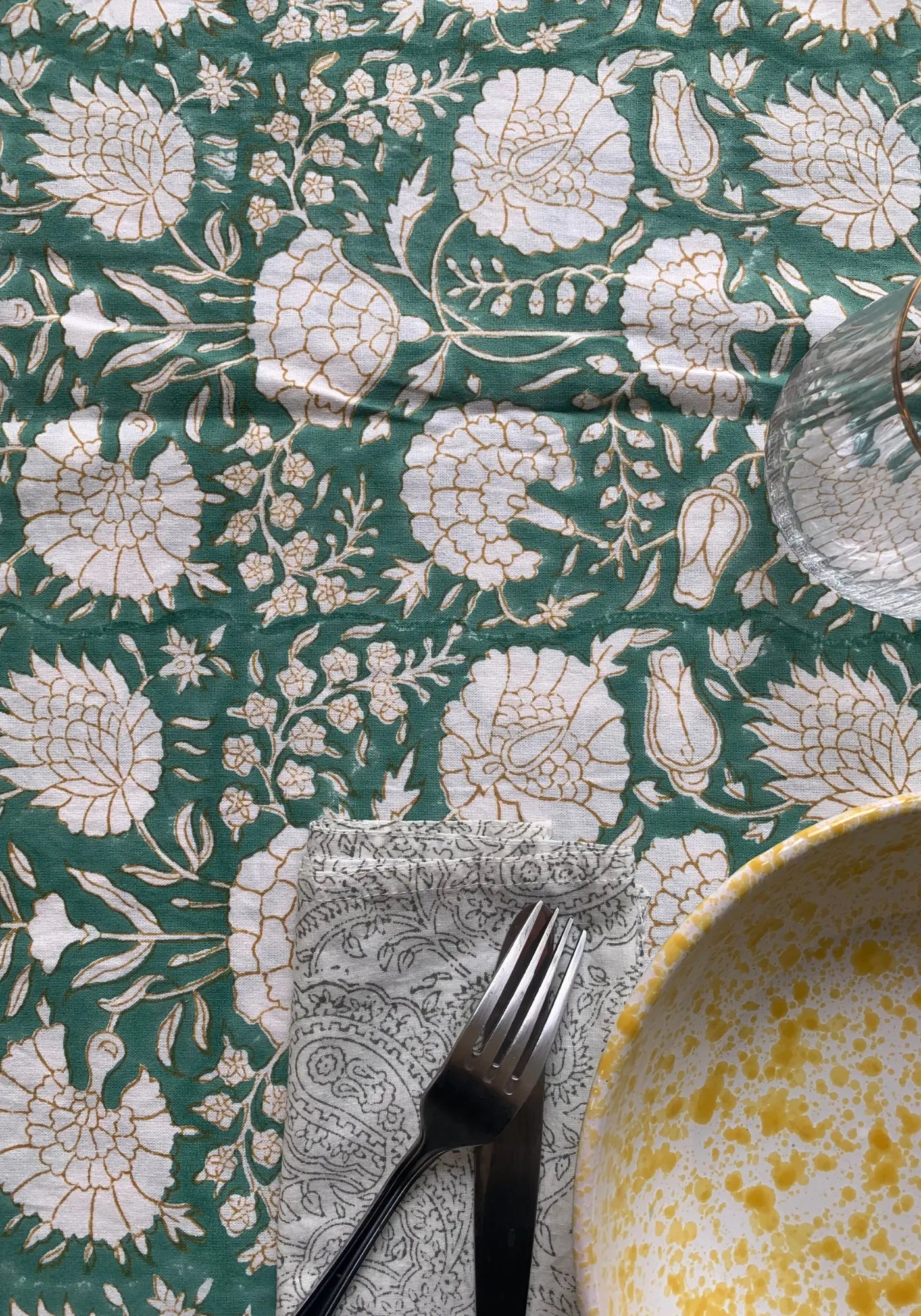 Zoom sur la nappe verte au blockprint ocre et bleu de chez Les Petits Bohèmes