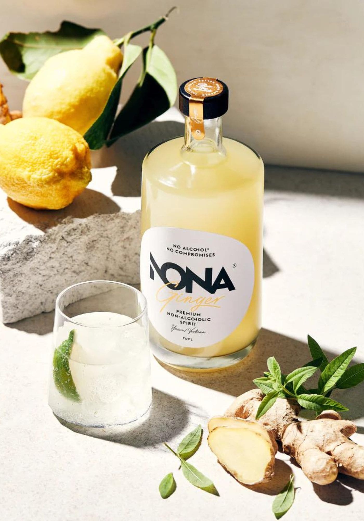 La bouteille de Nona Ginger est au soleil à côté d'un verre rempli de ce cocktail sans alcool
