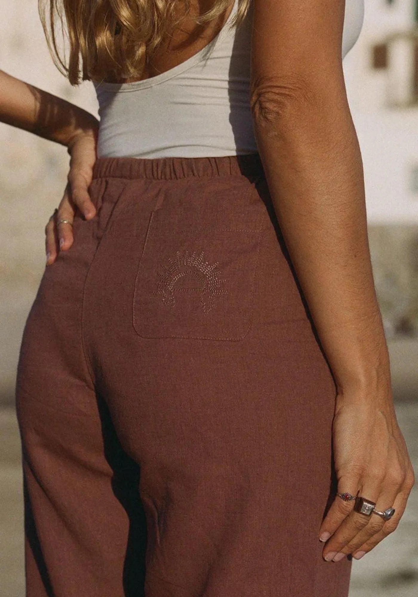 Zoom sur la femme de dos qui porte le pantalon Bahari marron de chez Nénés Paris