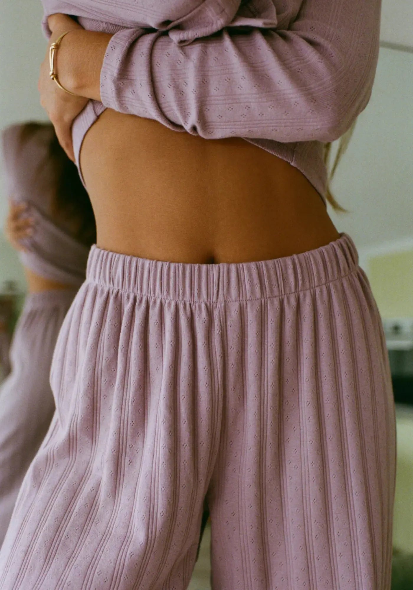 La femme porte le pantalon Maud mauve de chez Nénés Paris 