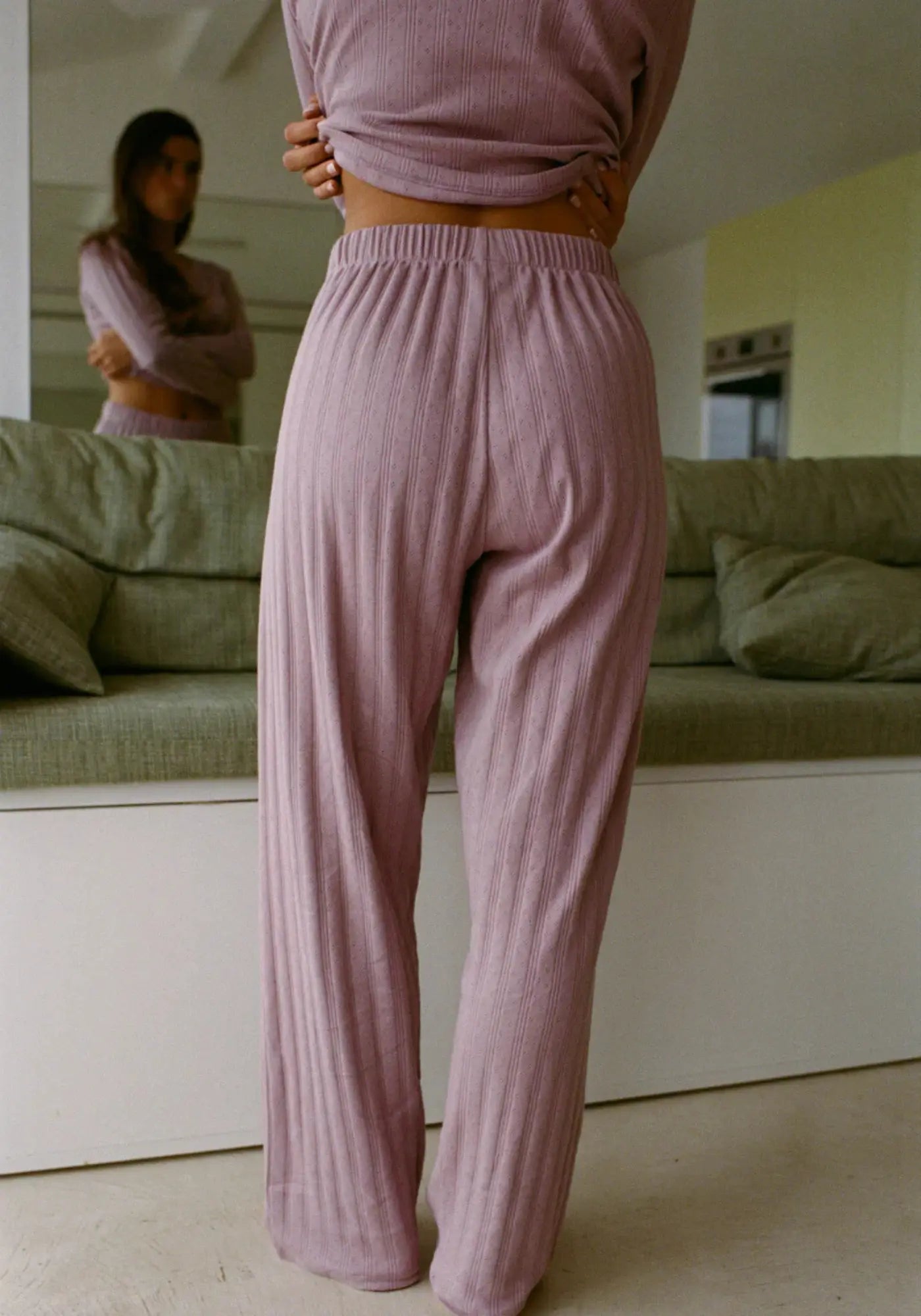 La femme est de dos et porte le pantalon Maud mauve de chez Nénés Paris 