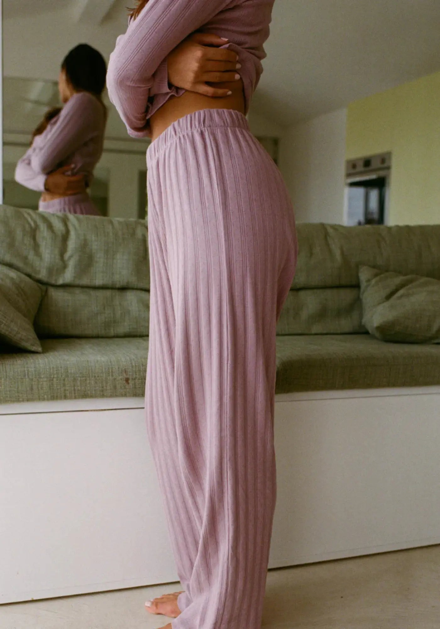 La femme porte le pantalon Maud mauve de chez Nénés Paris 