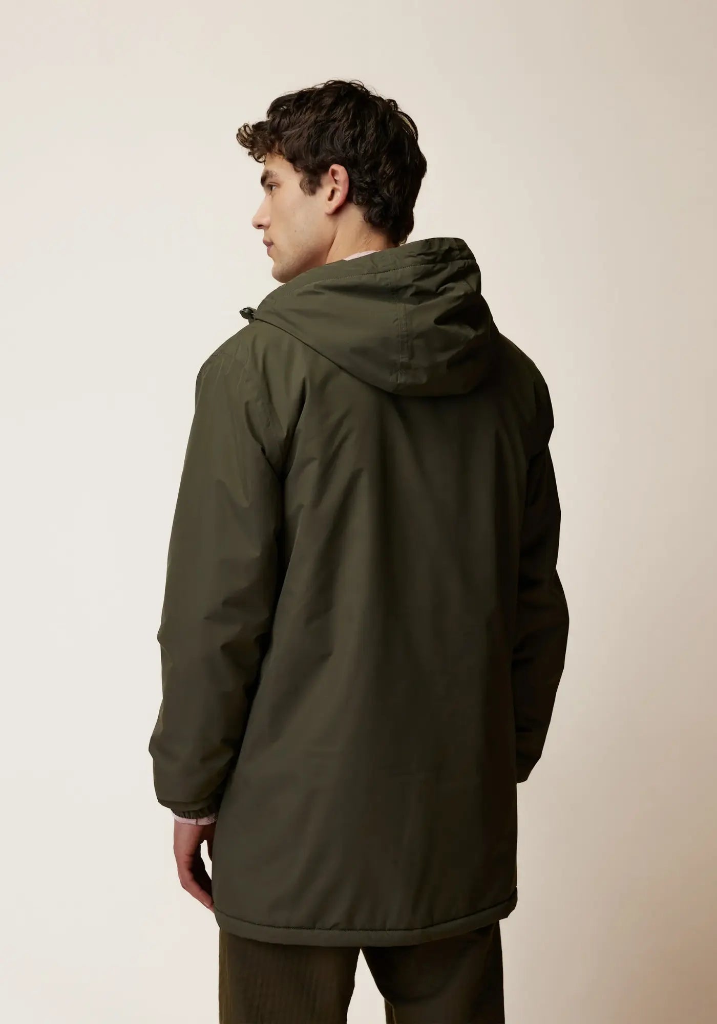 L'homme est de dos et porte la parka imperméable montaud de chez Faguo