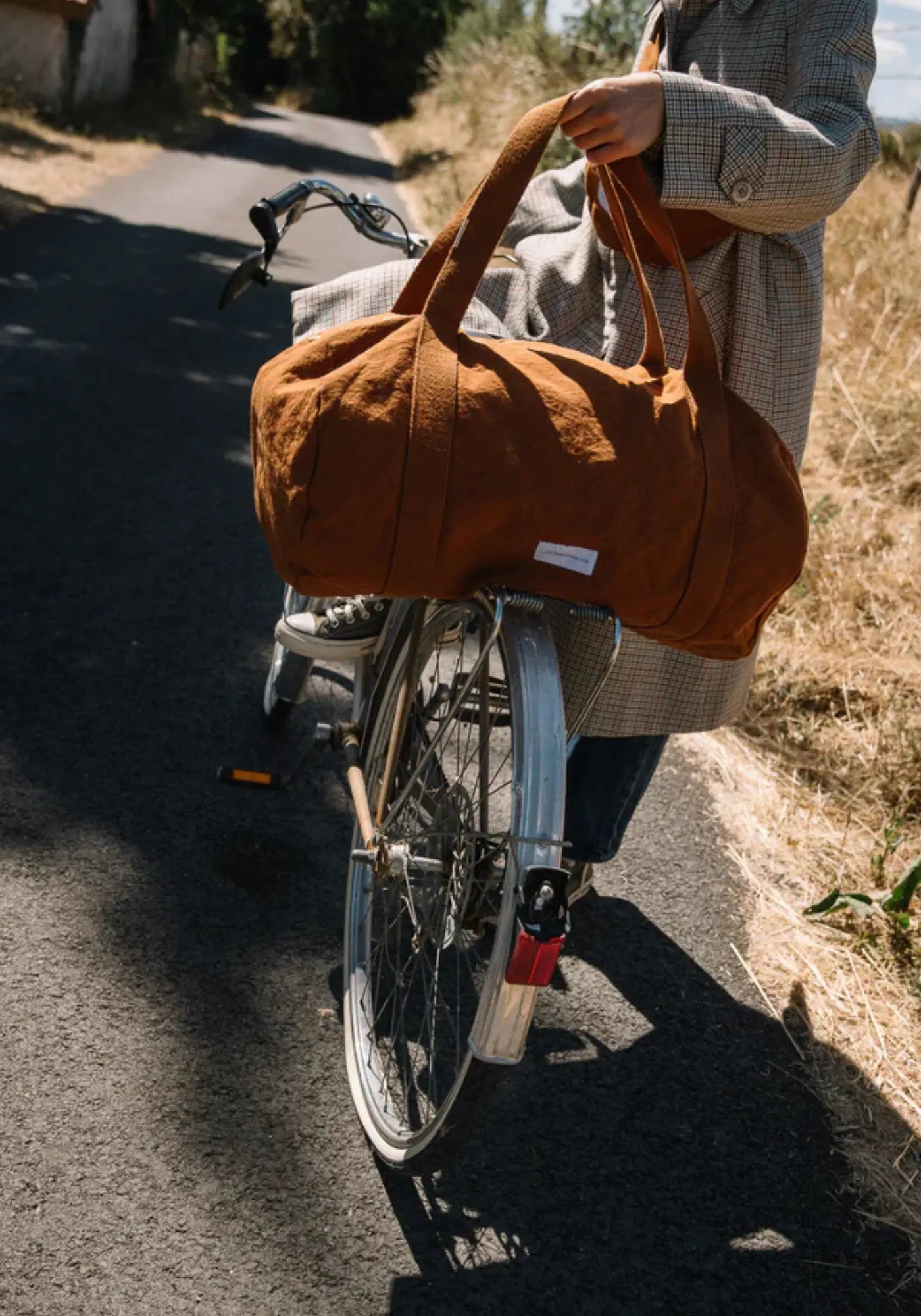 La femme porte le sac bowling marron caramel des Pensionnaires