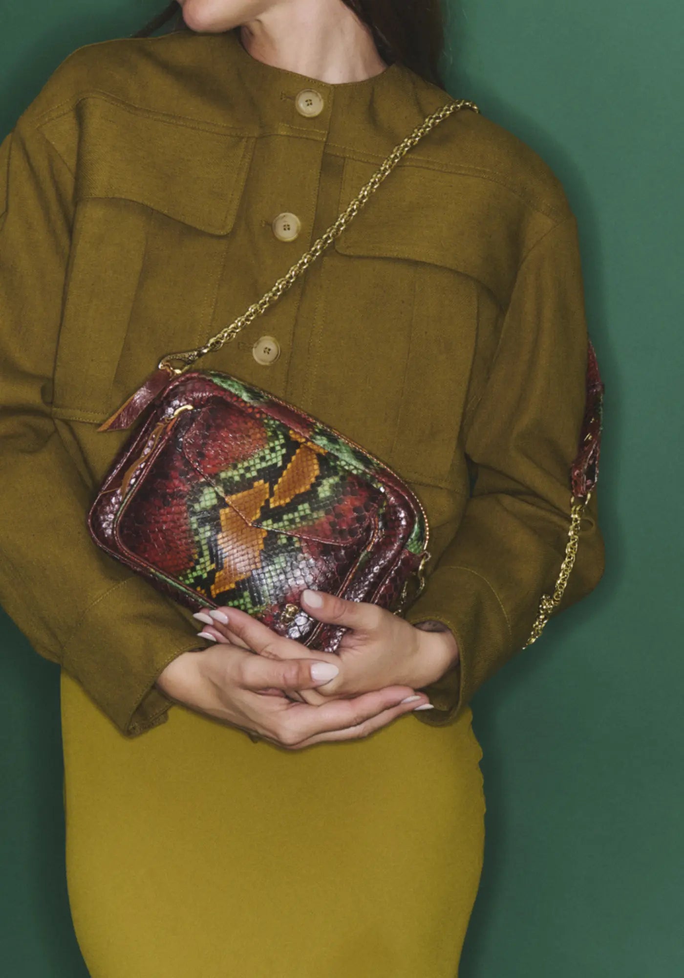 La femme porte le sac Charly python oasis de chez Claris Virot 