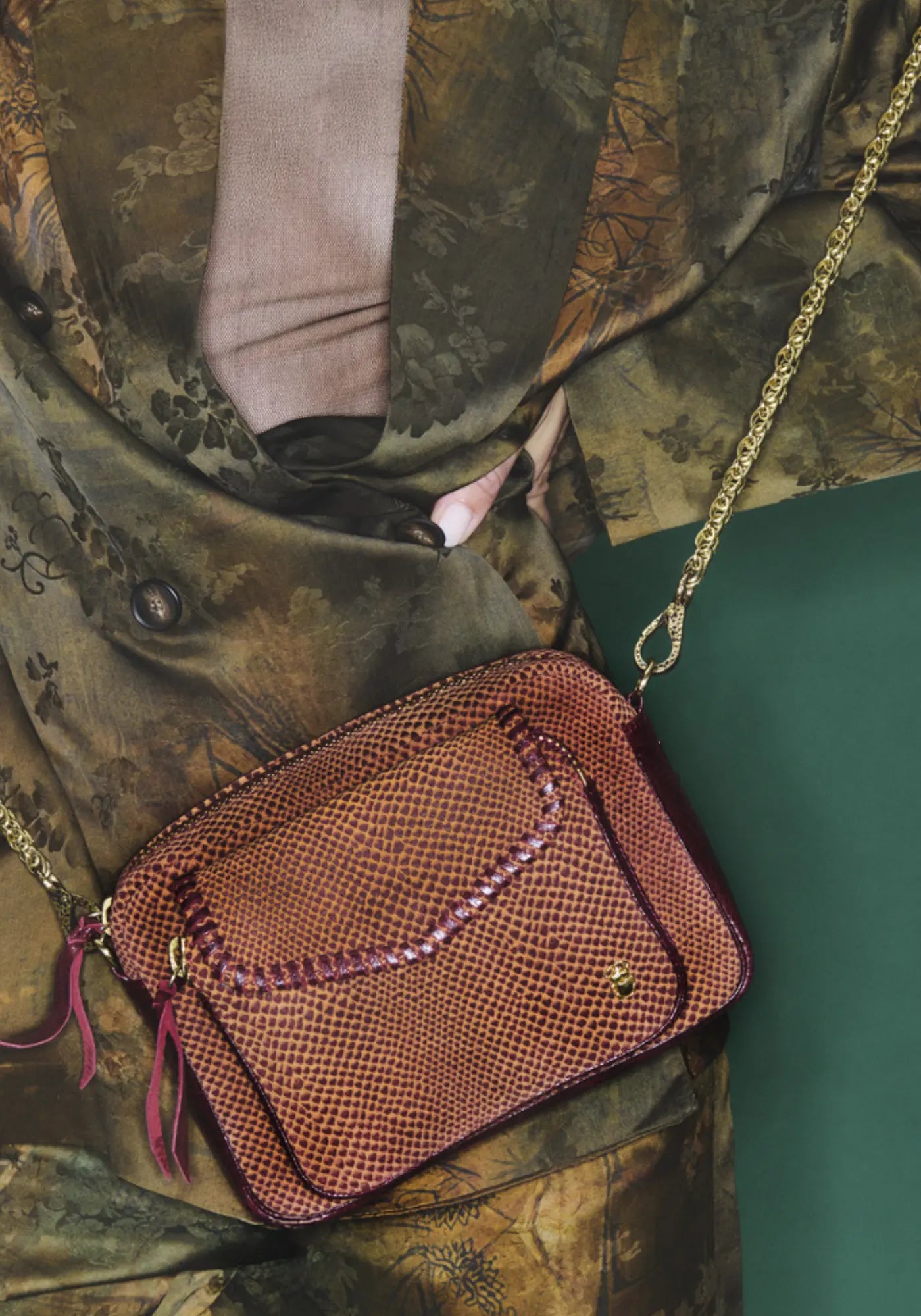 La femme porte le sac charly veau velours sekhmet de chez Claris Virot 