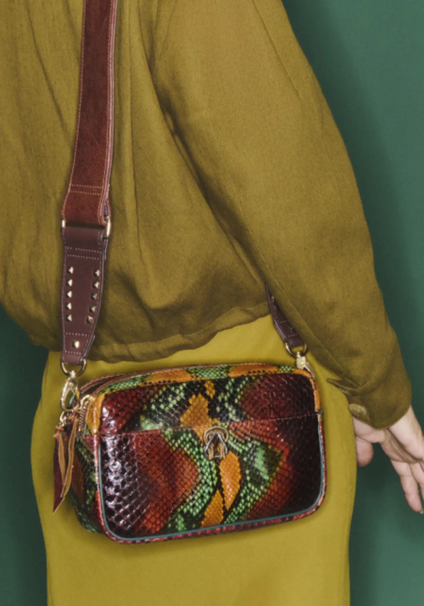 La femme porte le sac Lily python oasis de chez Claris Virot 