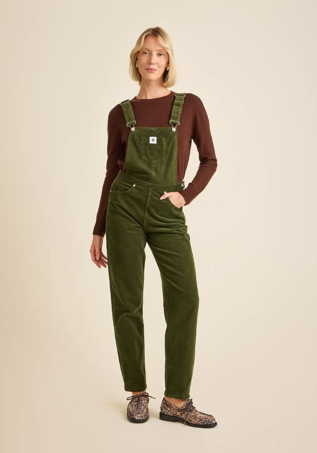 La femme porte la salopette mom coloris vert olive de chez Côtelé Paris 