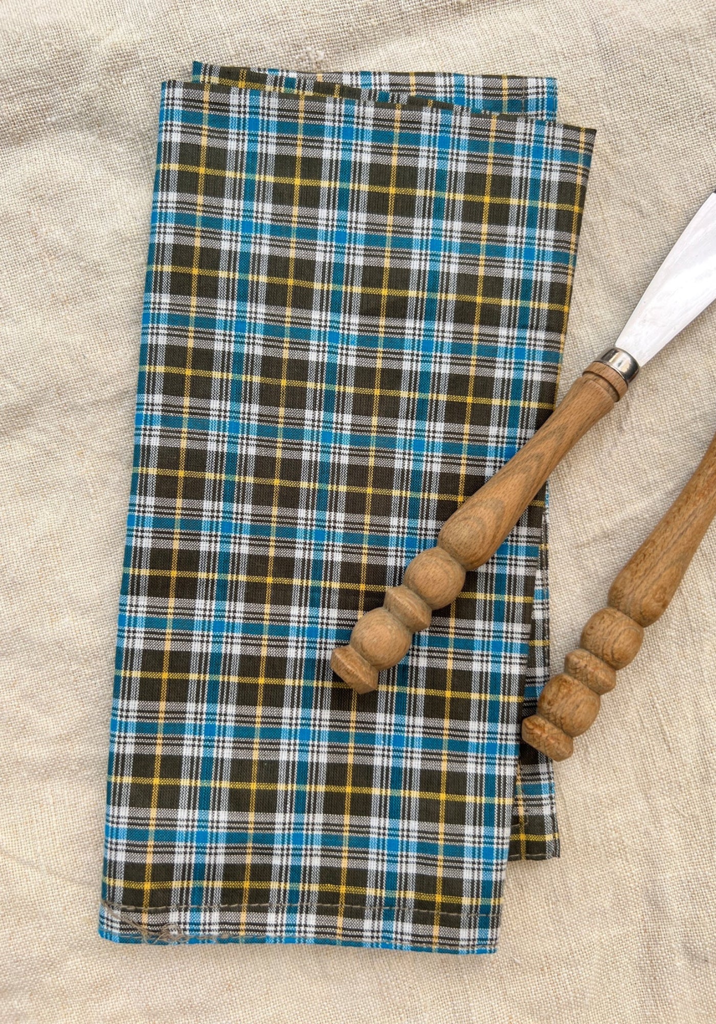 La serviette de table à carreaux kaki, bleu et jaune de chez Les Petits Bohèmes