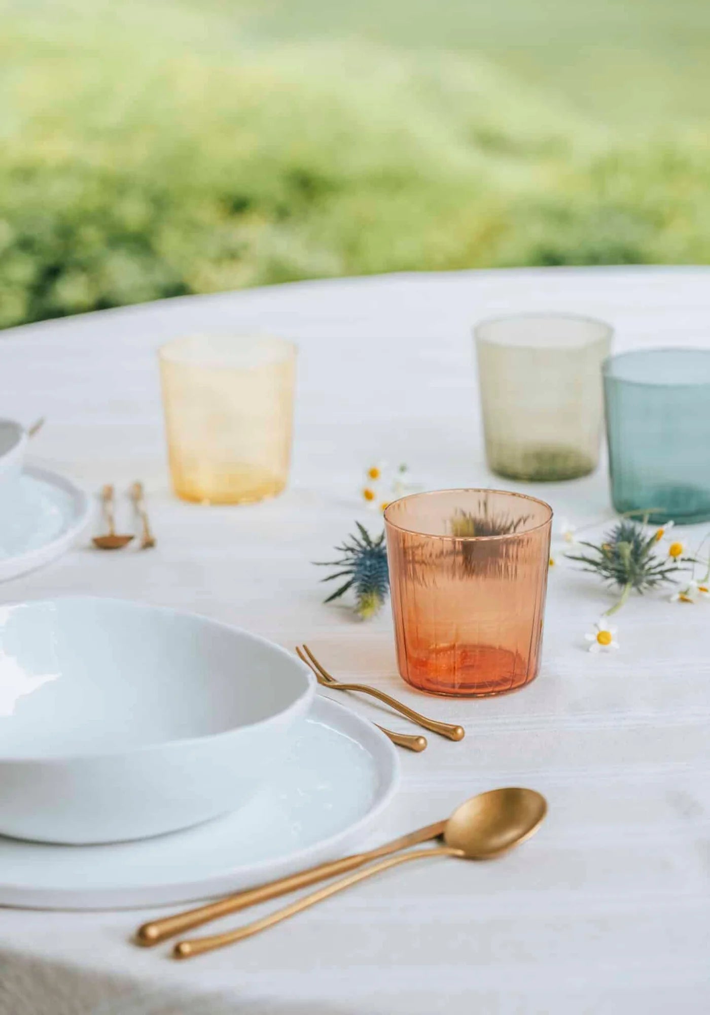 Les 4 verres colorés de chez Clover Gin posés sur une table dressée