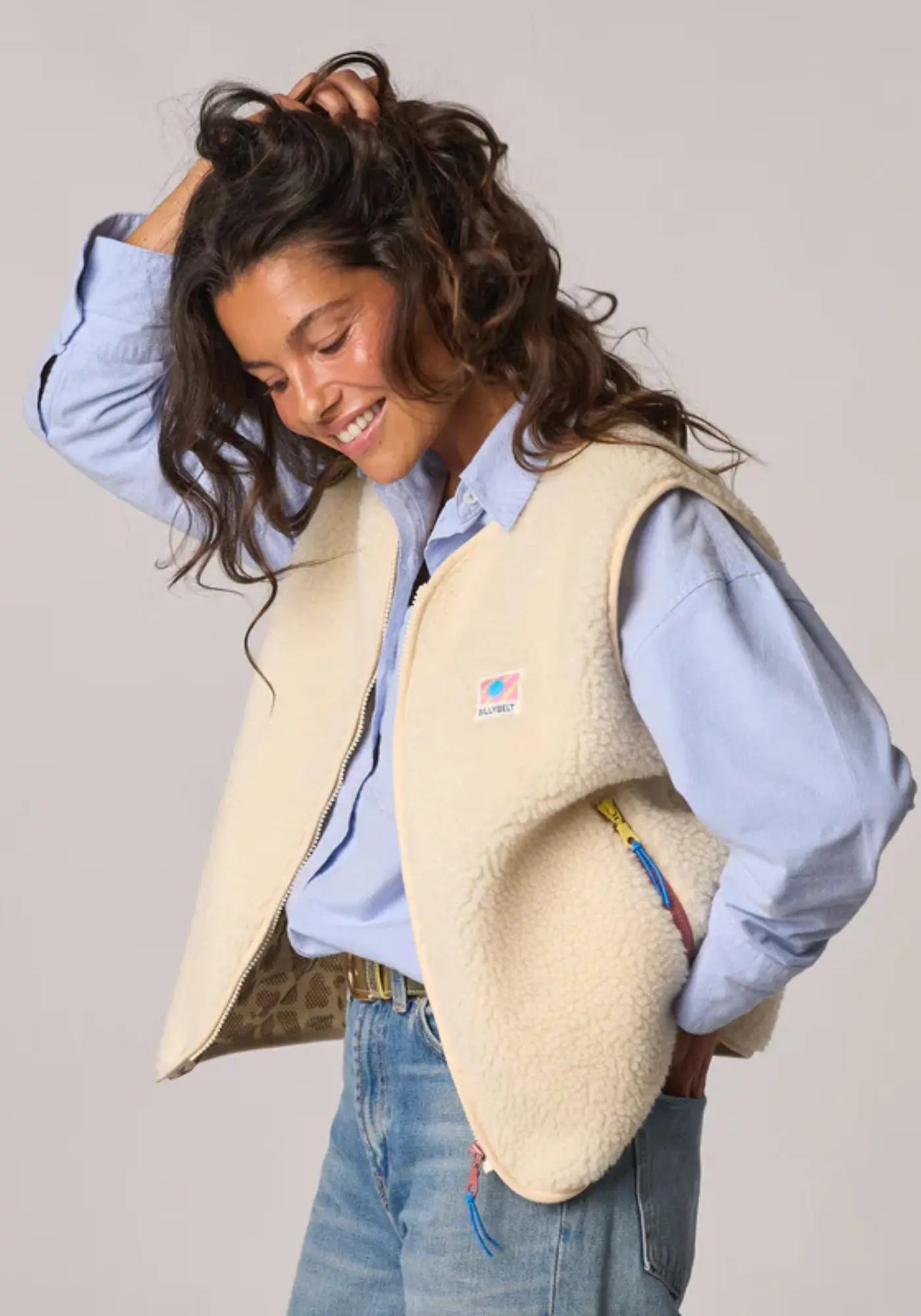 La femme porte la sherpa mixte zippée sans manches ivoire de chez Billybelt