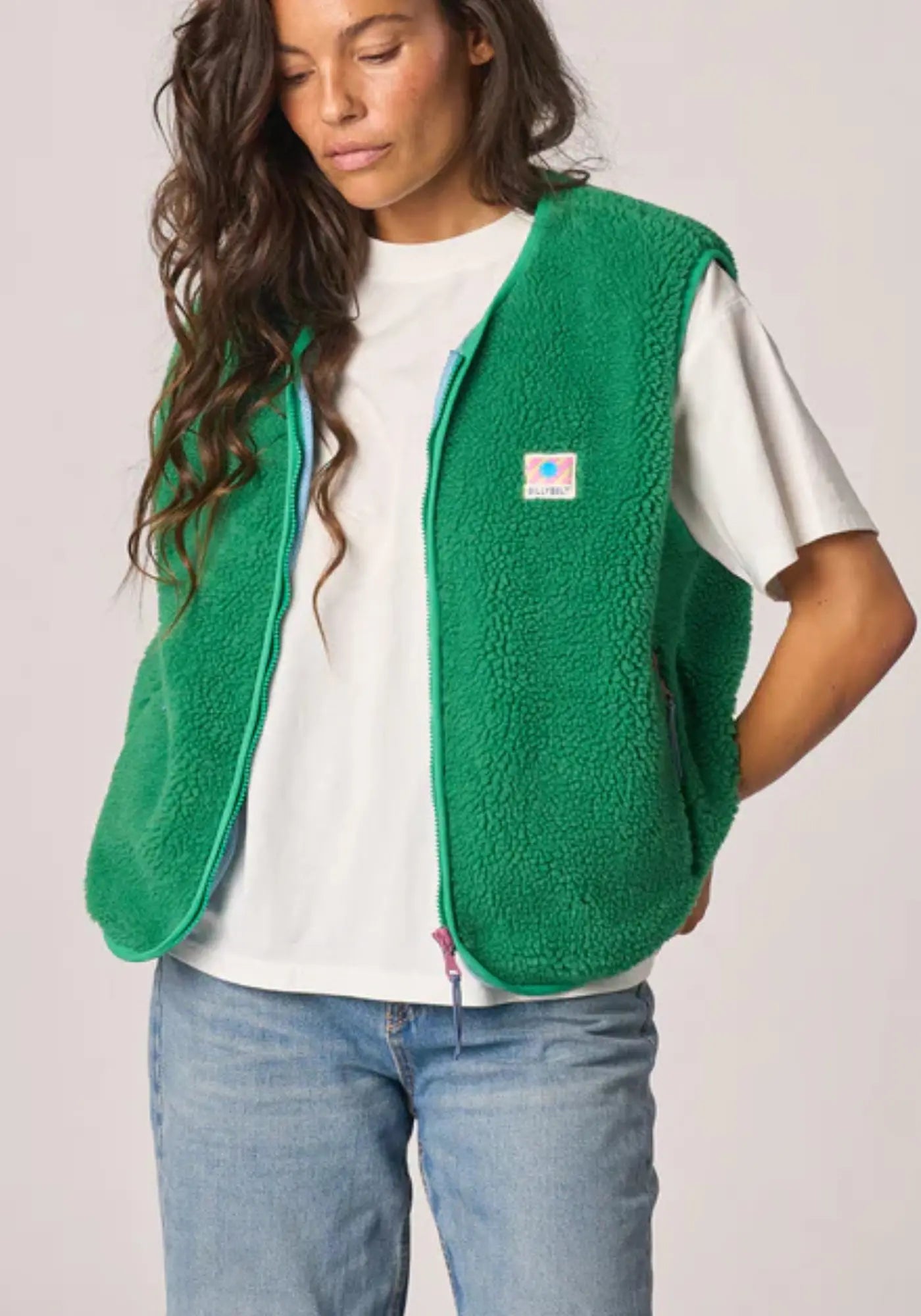 La femme porte la sherpa mixte zippée sans manches vert de chez Billybelt