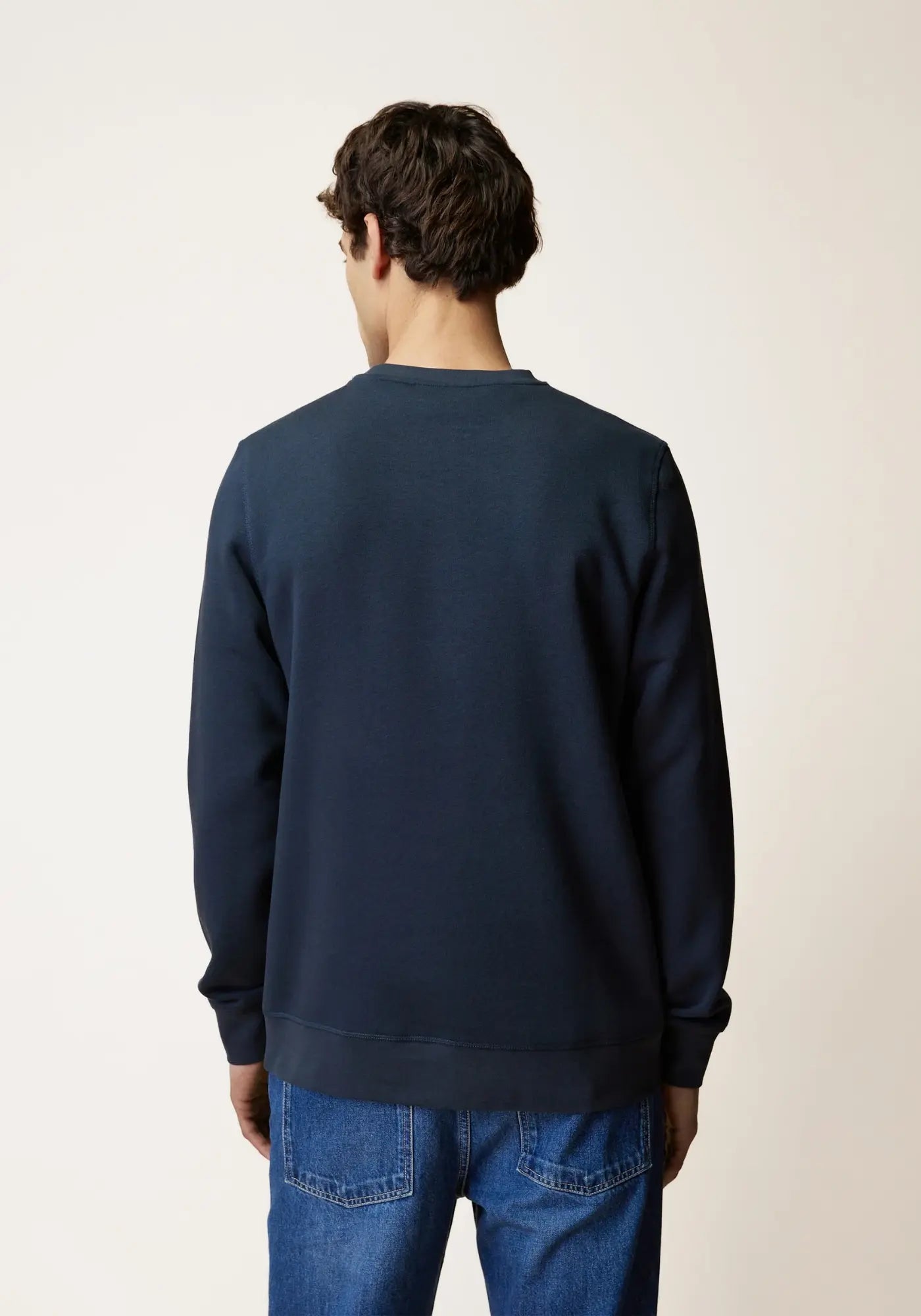 L'homme est de dos et porte le sweat donzy bleu marine de chez Faguo