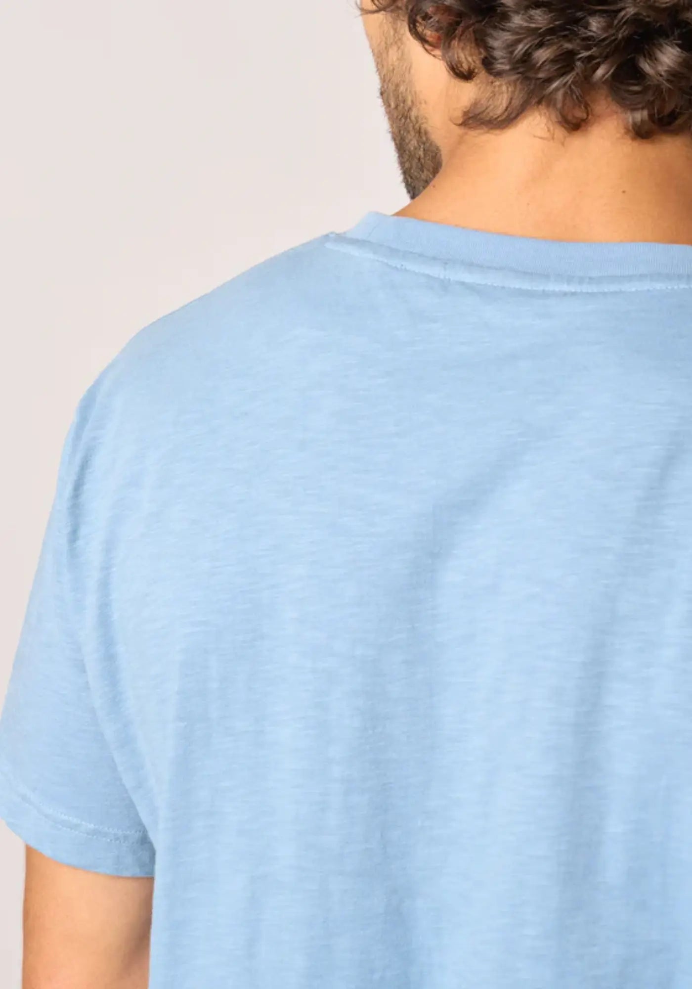 L'homme est de dos et porte le t-shirt dolce vita bleu ciel de chez Billybelt
