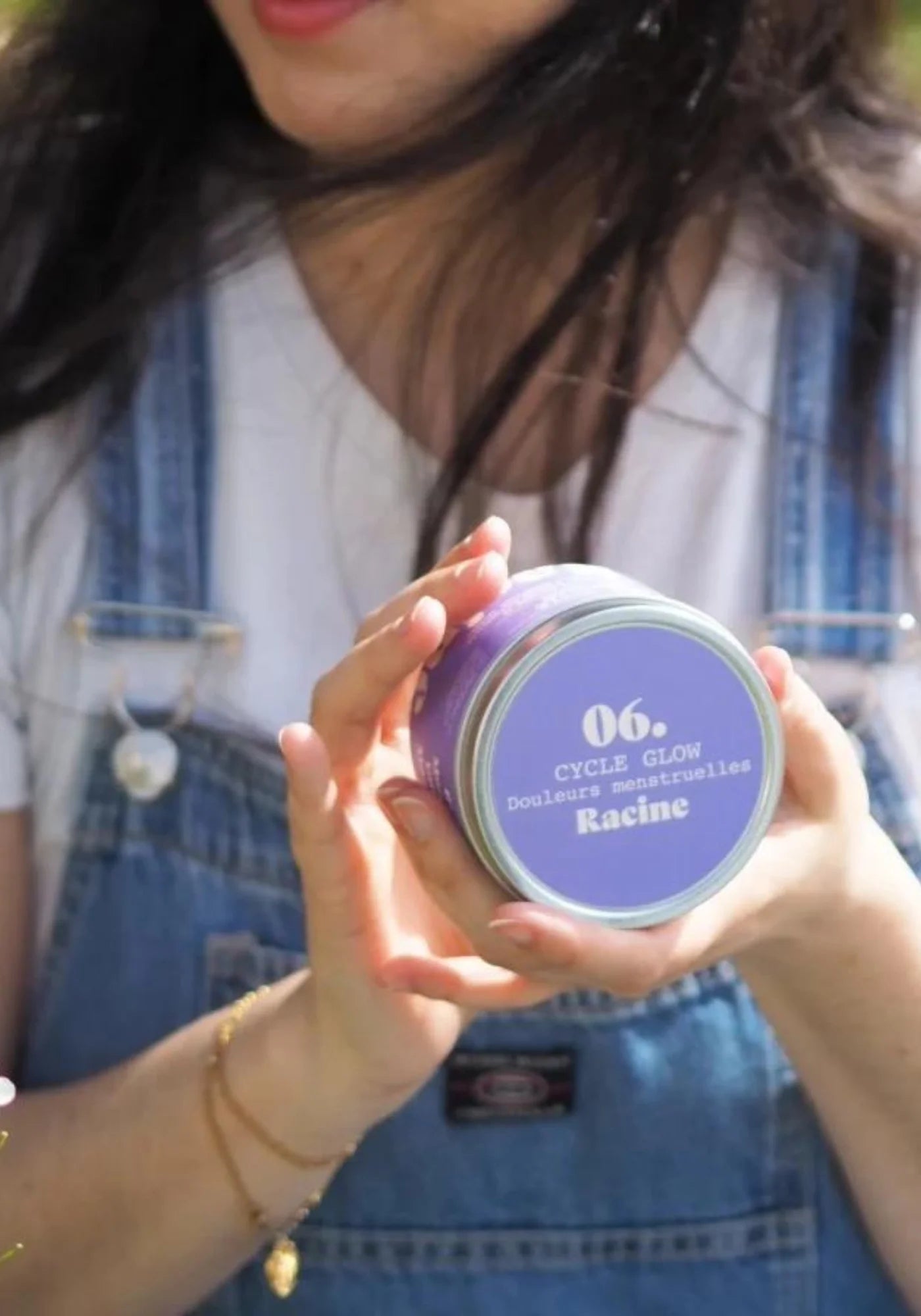 La femme tient entre ses mains la tisane Cycle Glow de chez Racine