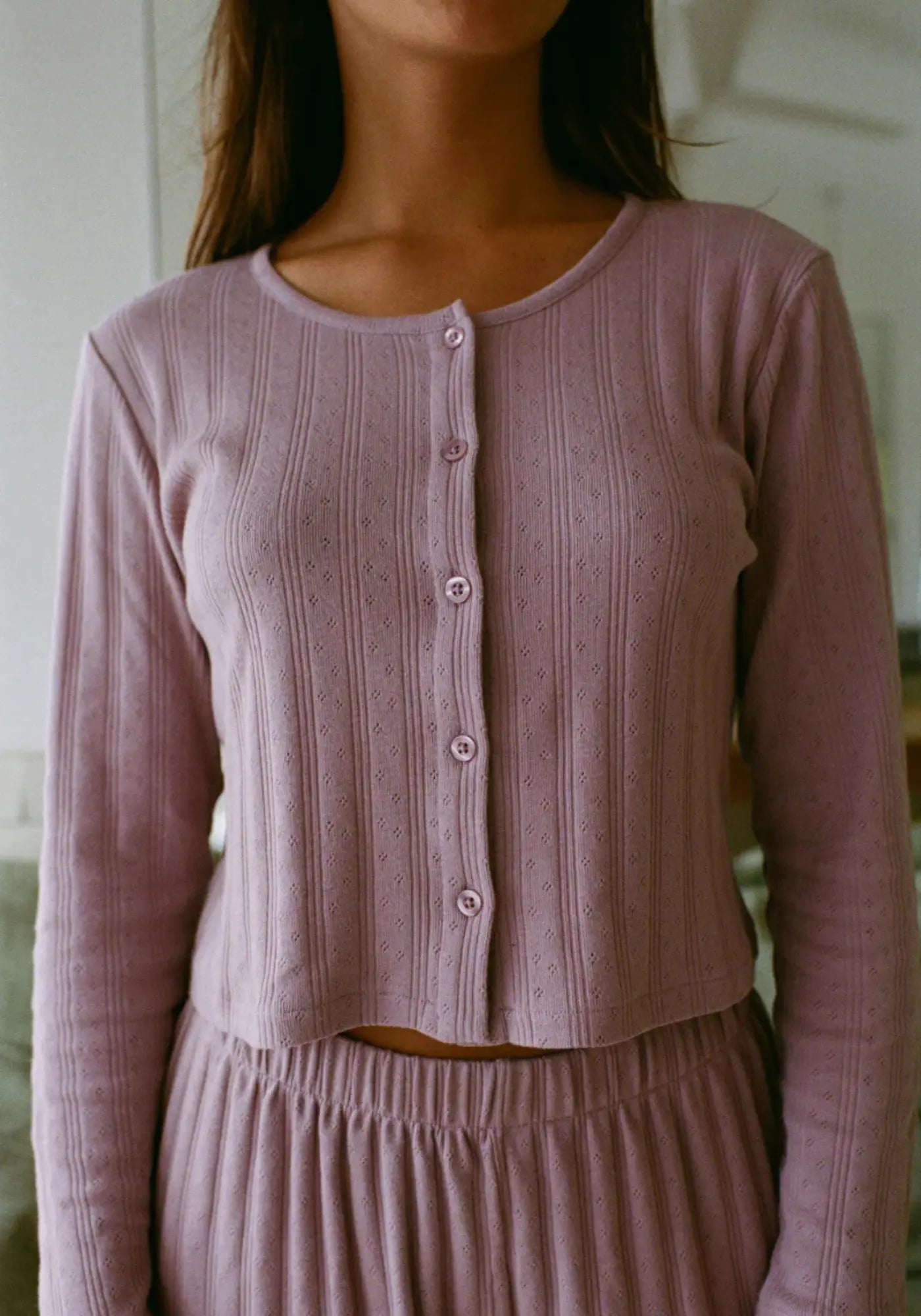 La femme porte le top Maud mauve de chez Nénés Paris 